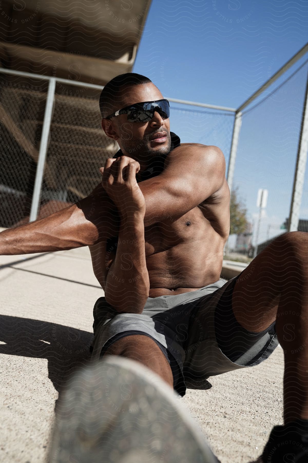 A man wears sunglasses as he sits on the pier