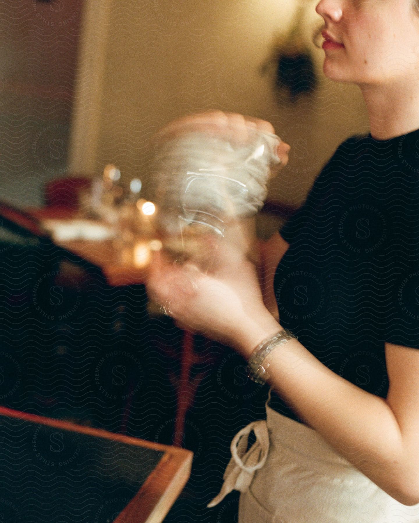 A woman holds a shaker and mixes a drink