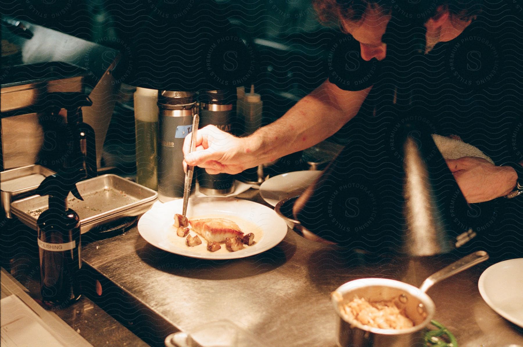 Close-up of a man finishing a dish with salmon.