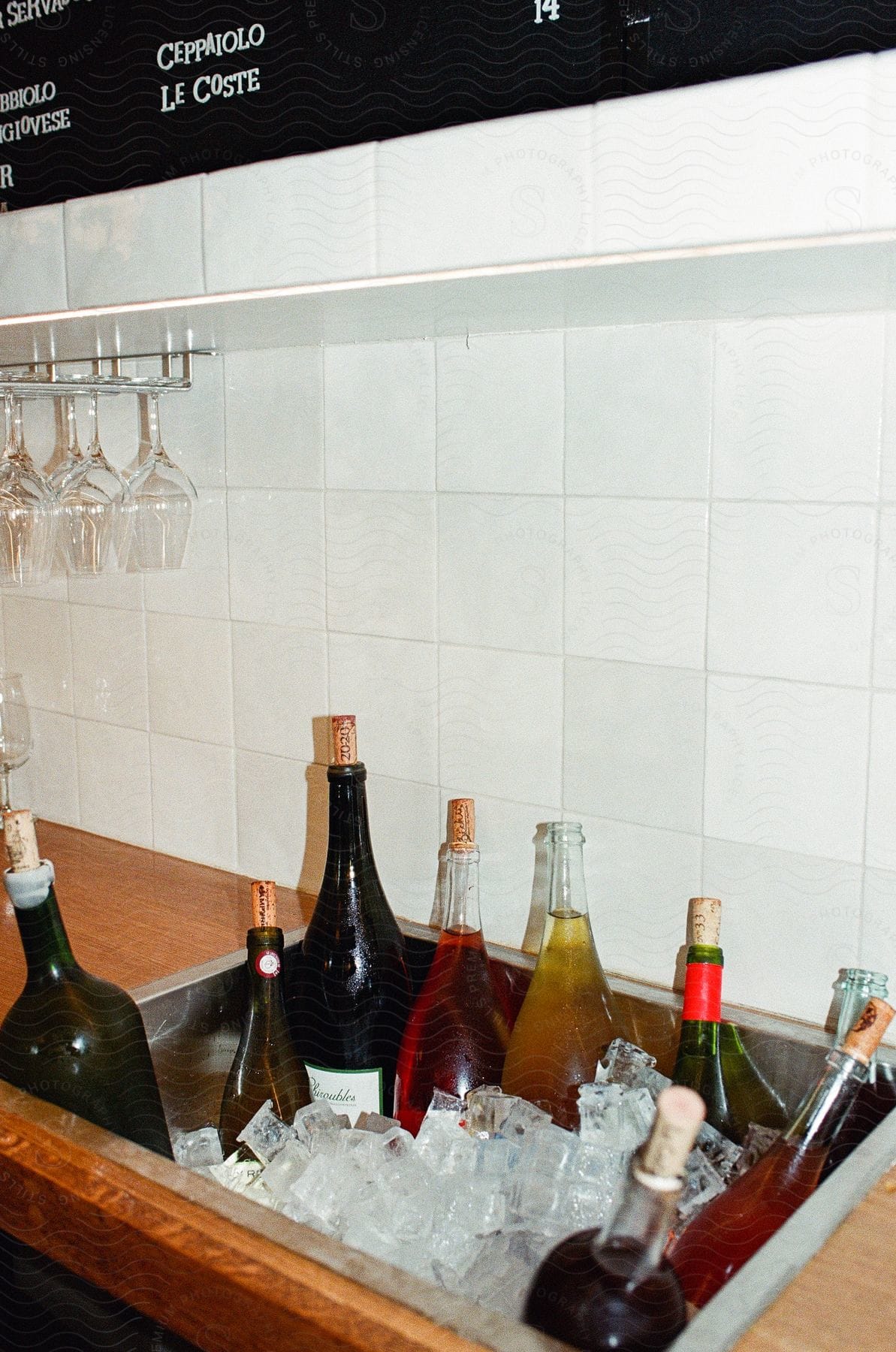 Some bottles of alcohol sitting in a sink full of ice.