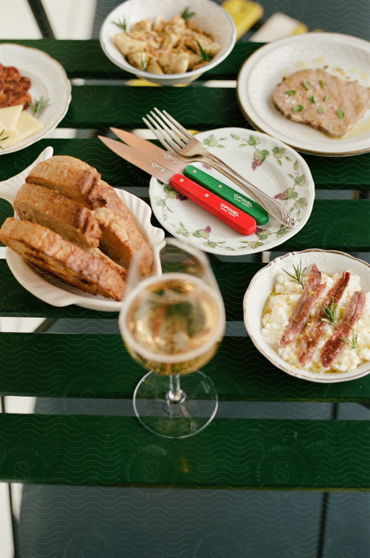 Close-up of a table with protein, bread, and a champagne glass.