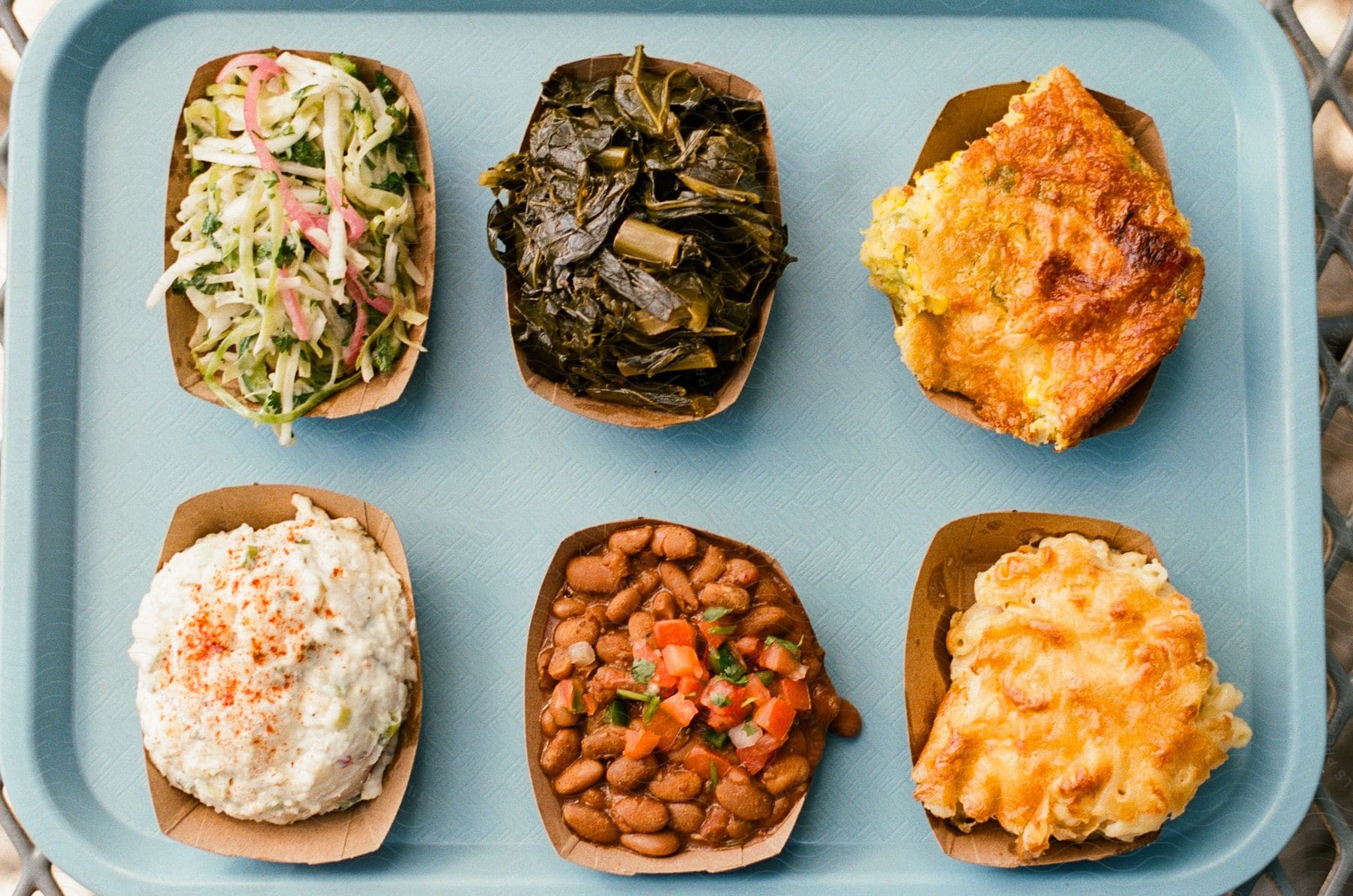 Some food sitting in cardboard trays on a plastic tray.