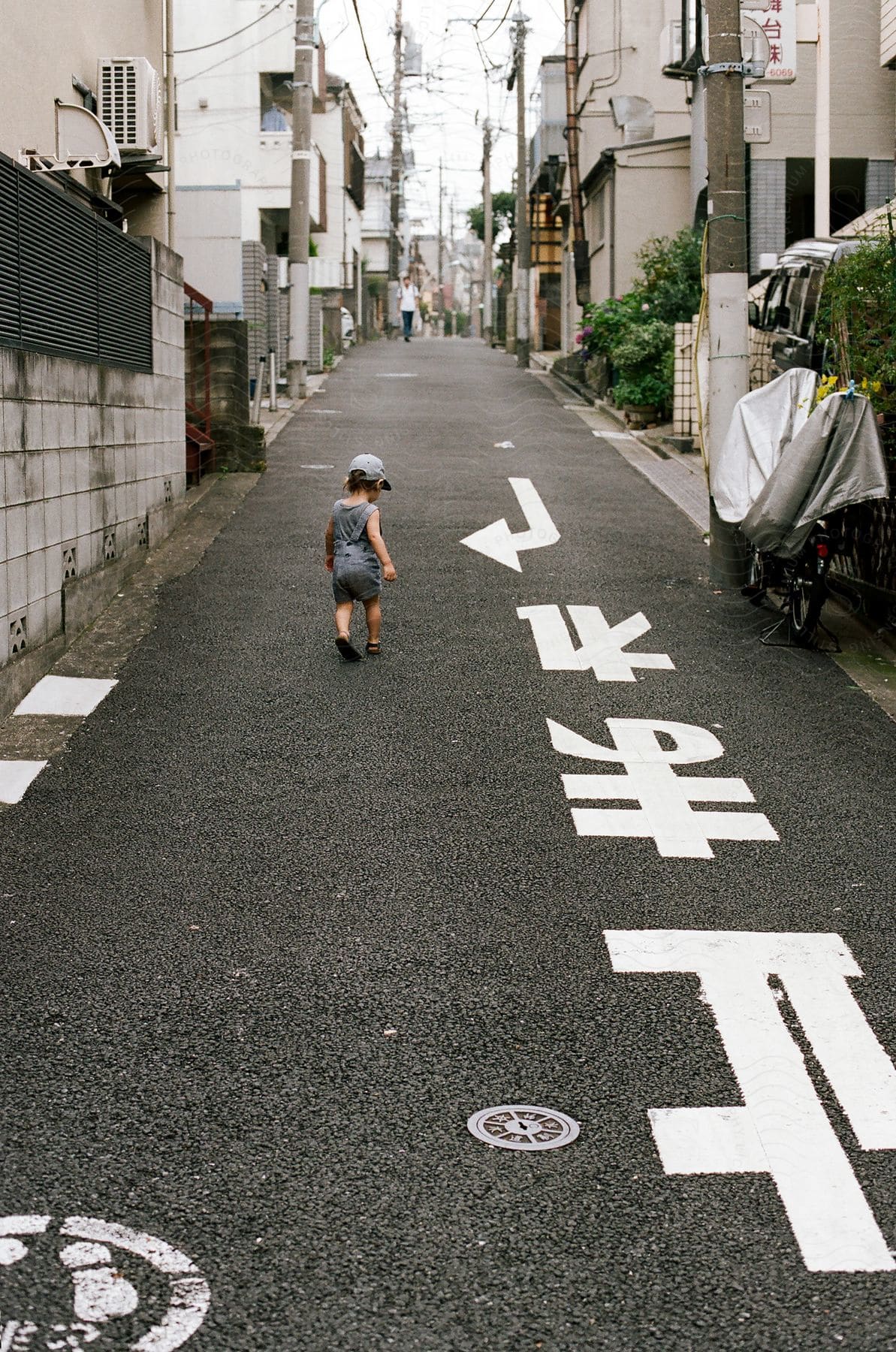 a child wearing a hat while walking in the middle of the street