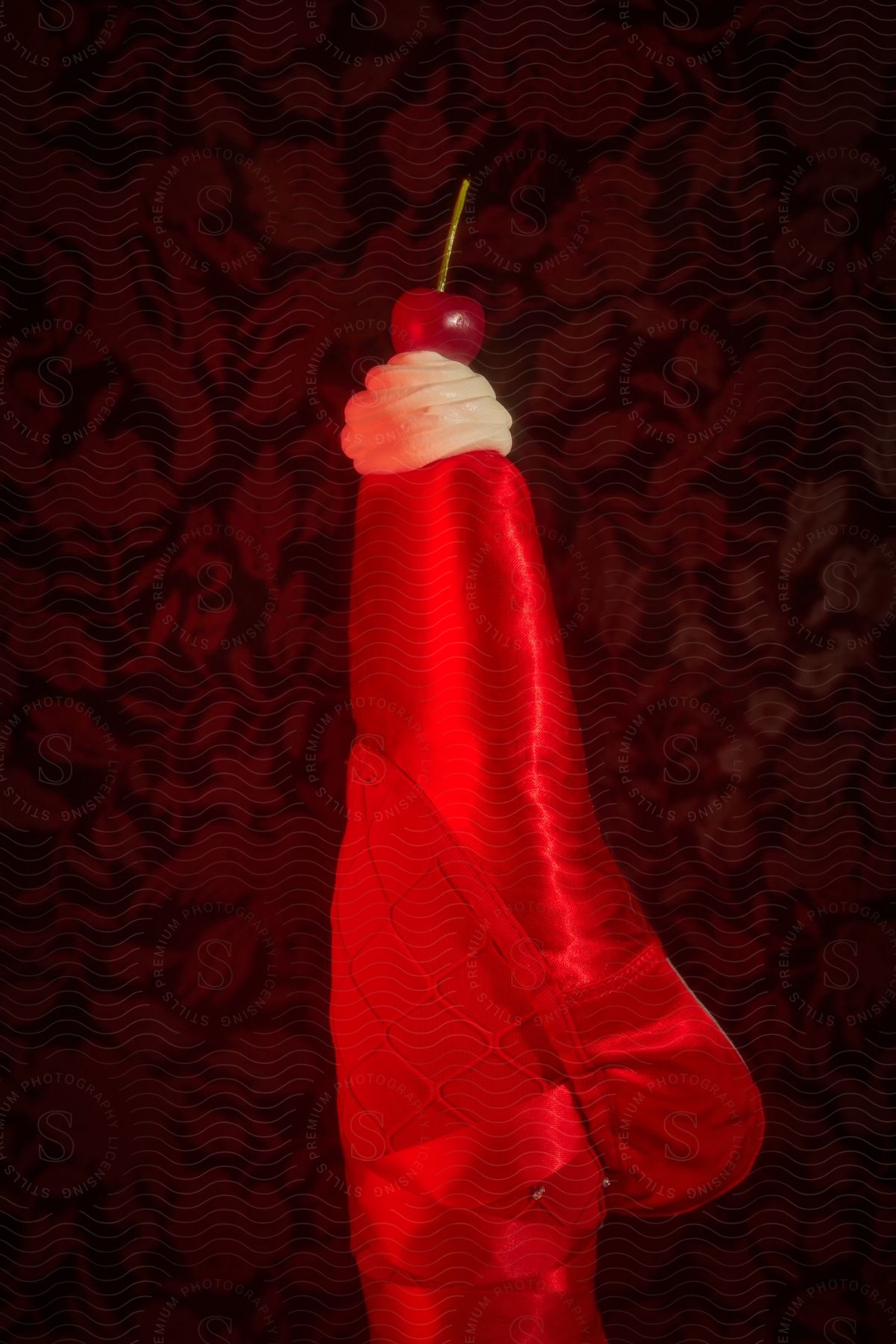 Cherry and candy on top of a red Christmas stocking