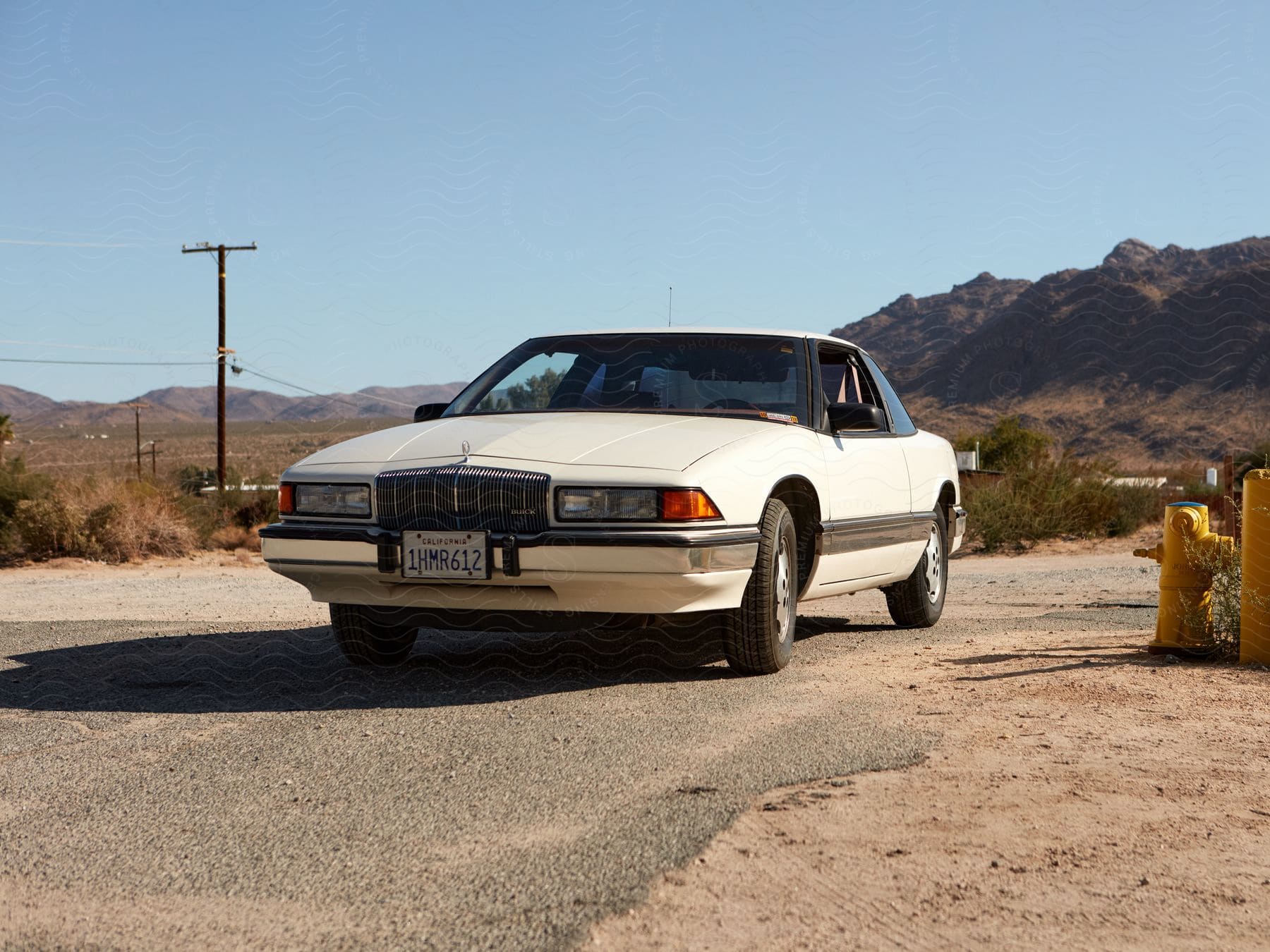 1993 Buick Regal on a road surrounded by a mountain range.