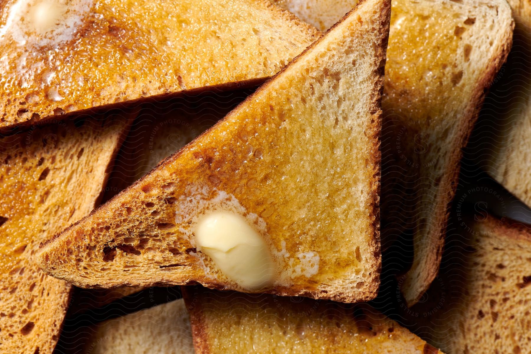 Slices of bread cut in half with melted butter