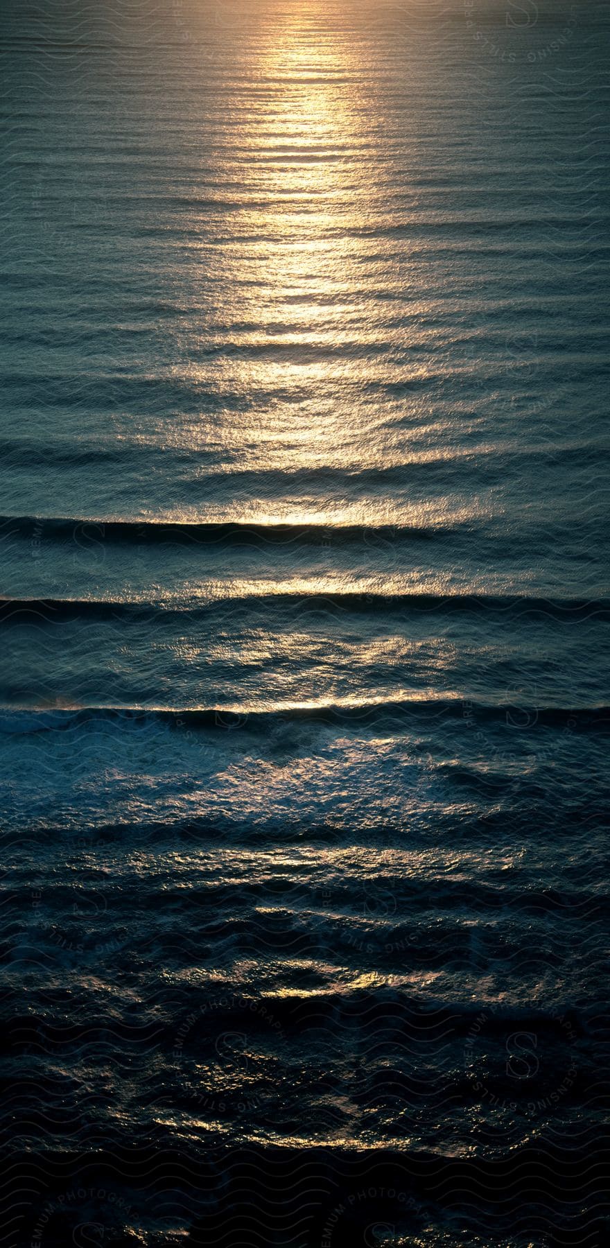 The setting sun reflects on the ripples and waves of the water