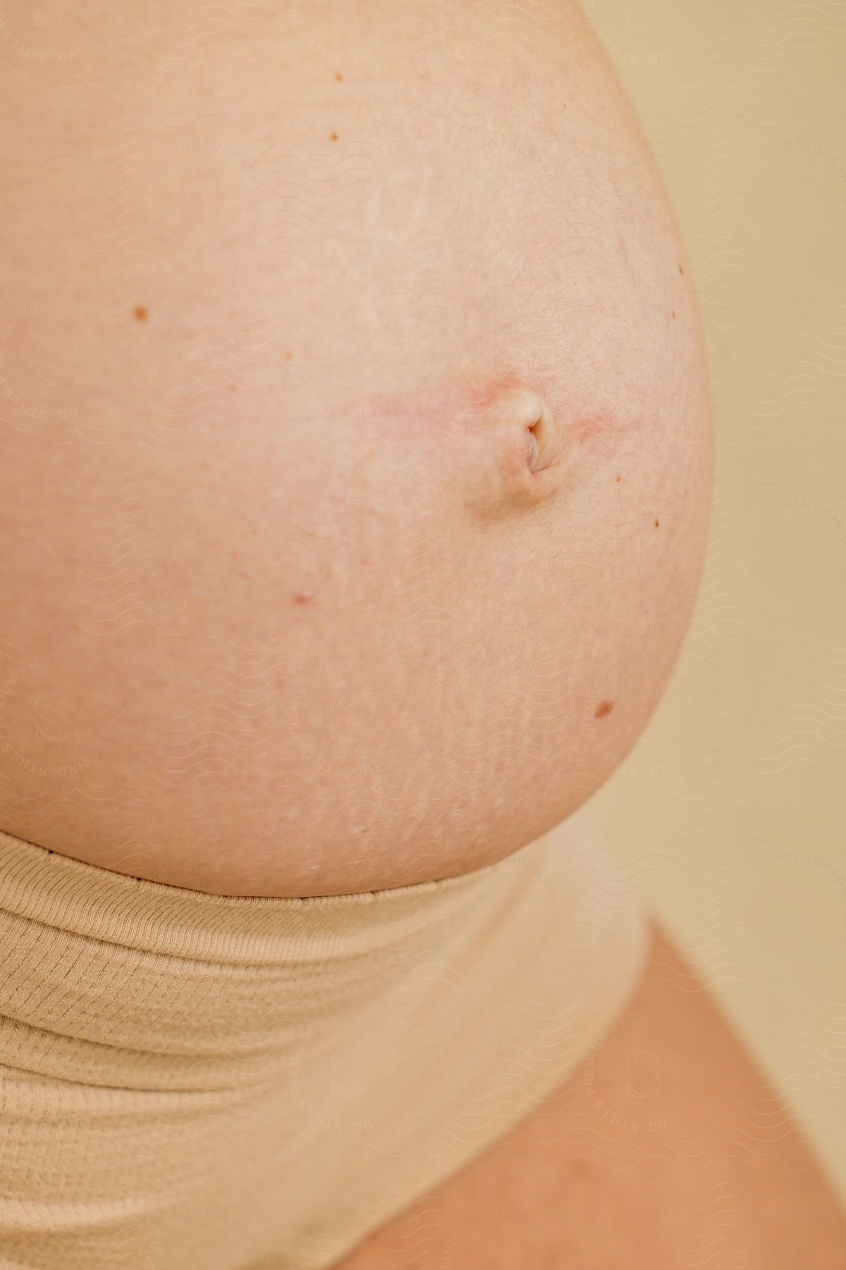 Close-up of a pregnant belly in a photo shoot.