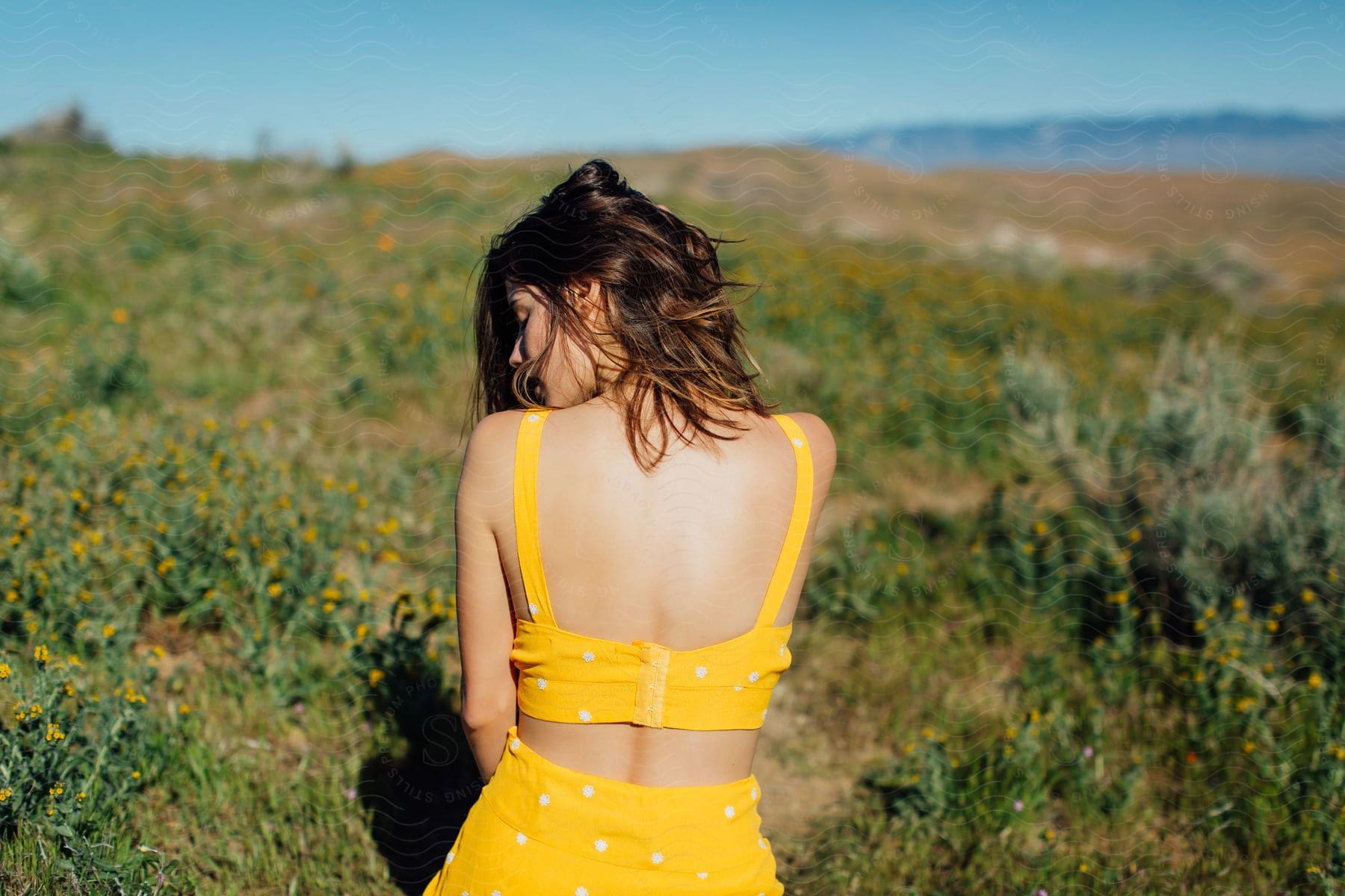 brown-haired girl on her knees at a meadow wearing yellow clothes outdoors during day time