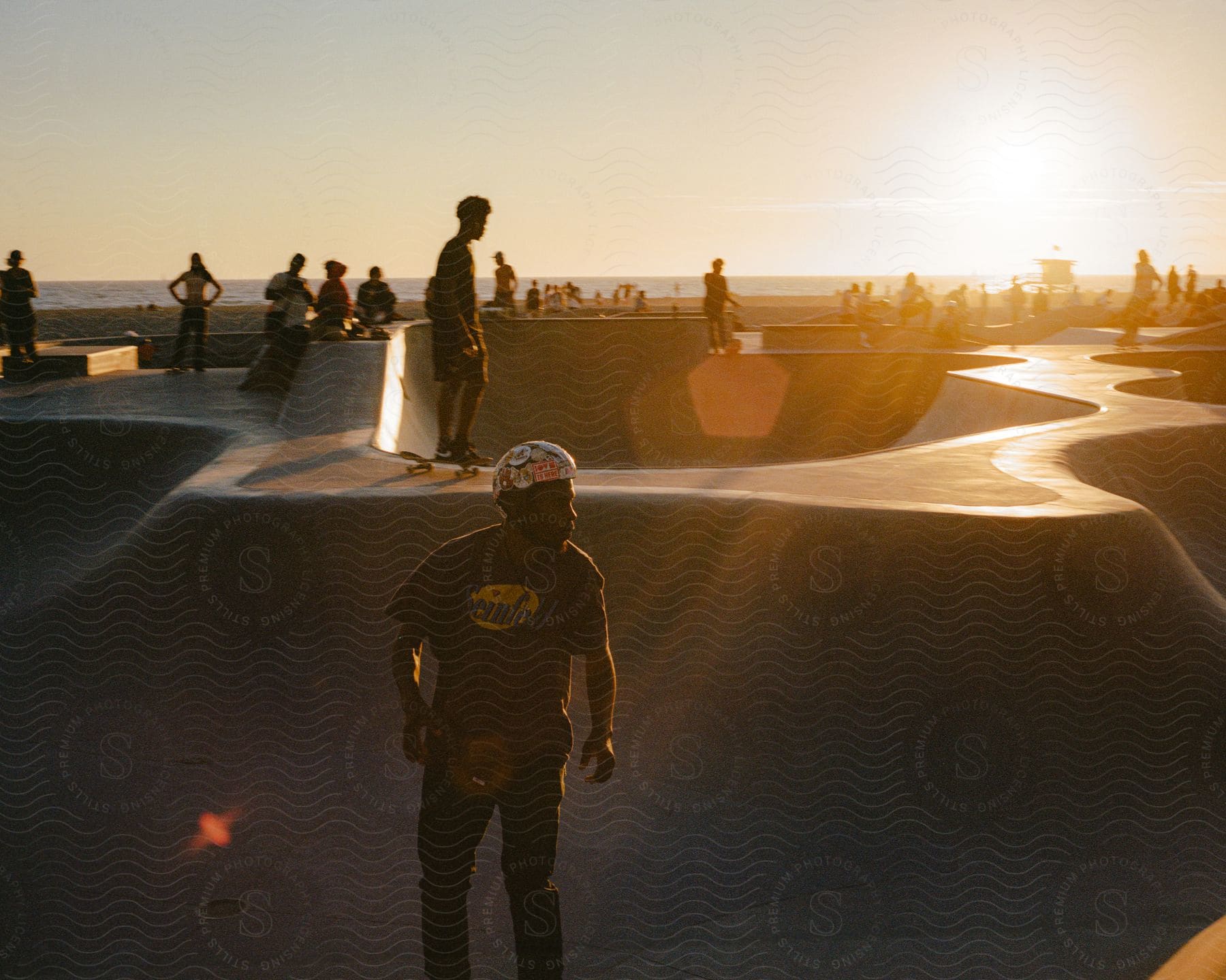 Panorama of a square in the late afternoon by the sea with people skateboarding