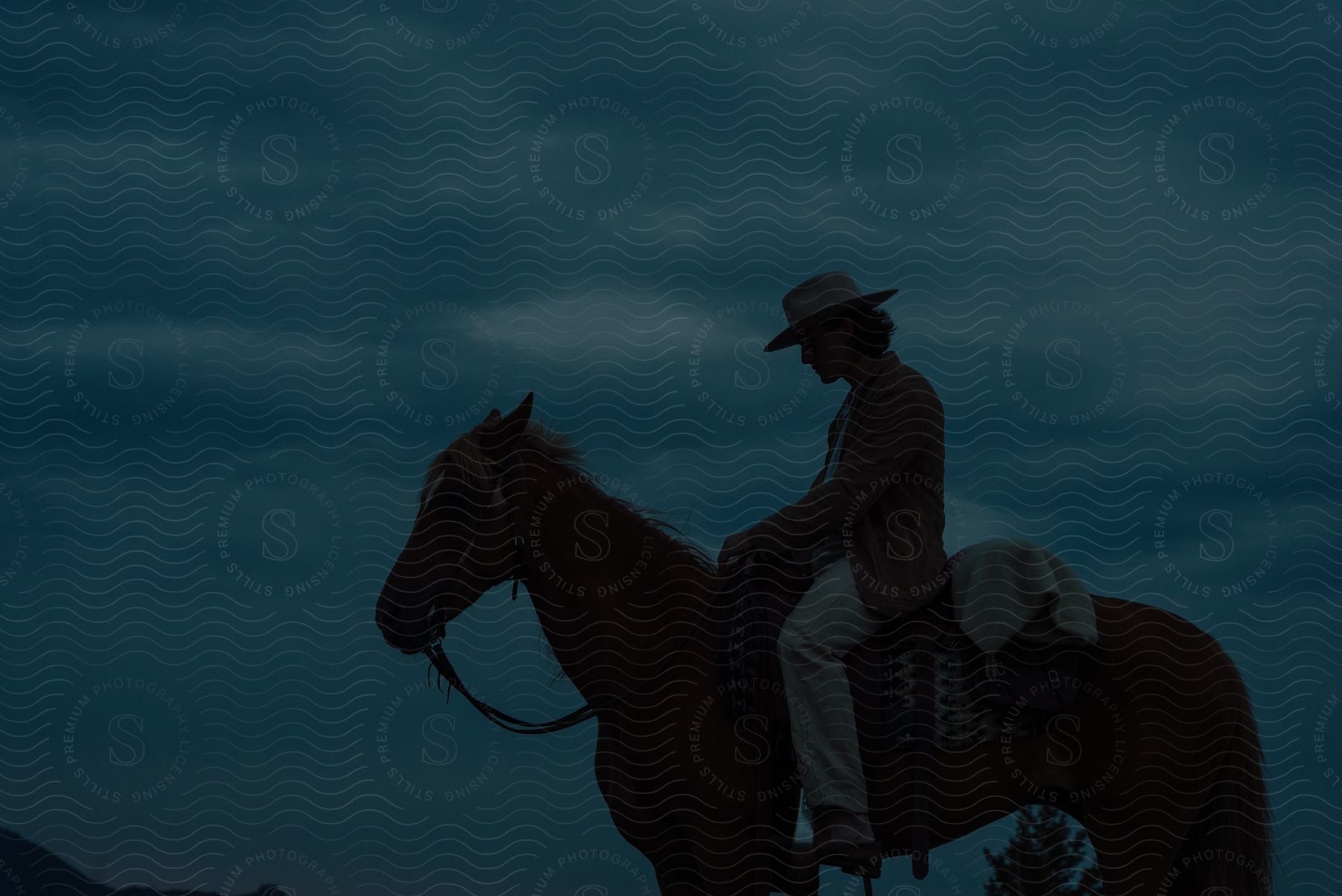 Man riding a horse on a cloudy and dark day