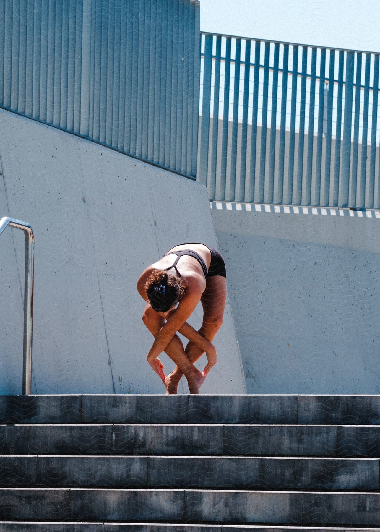 Model woman wearing sportswear placing her fingers on the heels of her feet