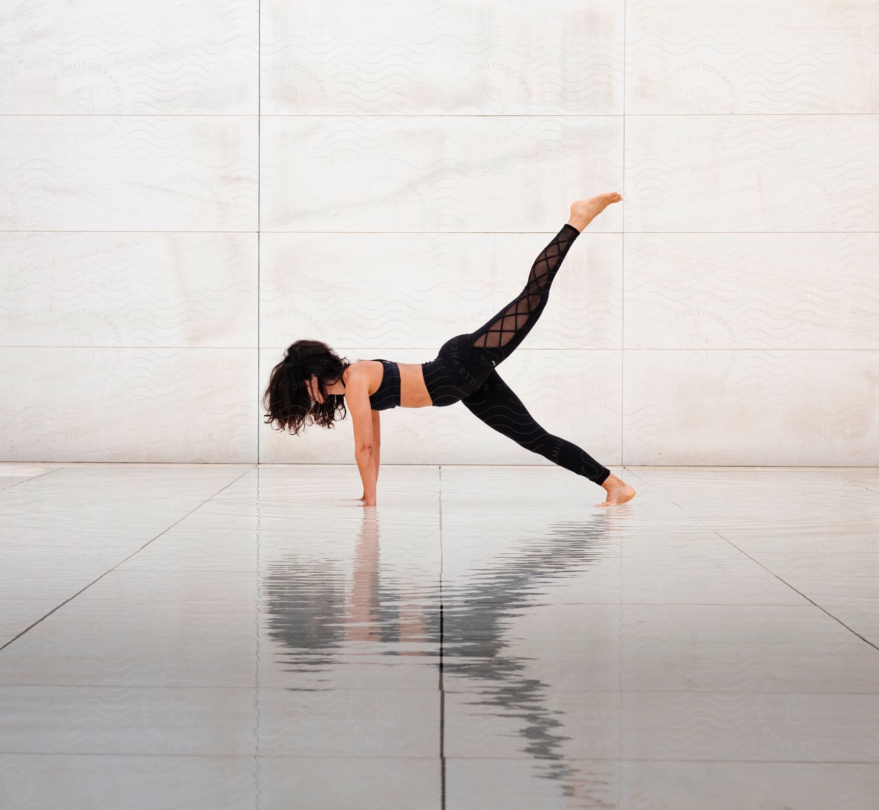 A women is stretching and has one leg lifted in the air.