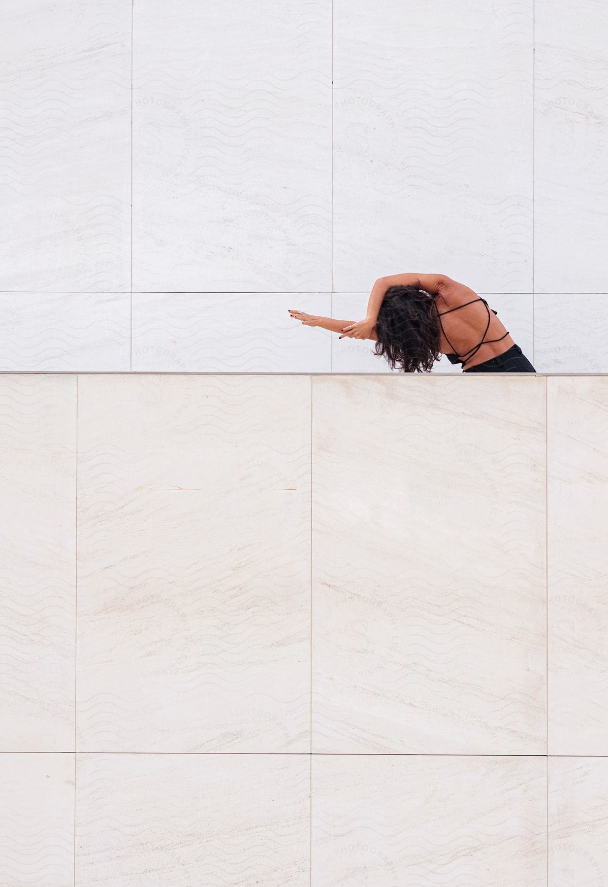 a woman is leaning to the left close to a wall