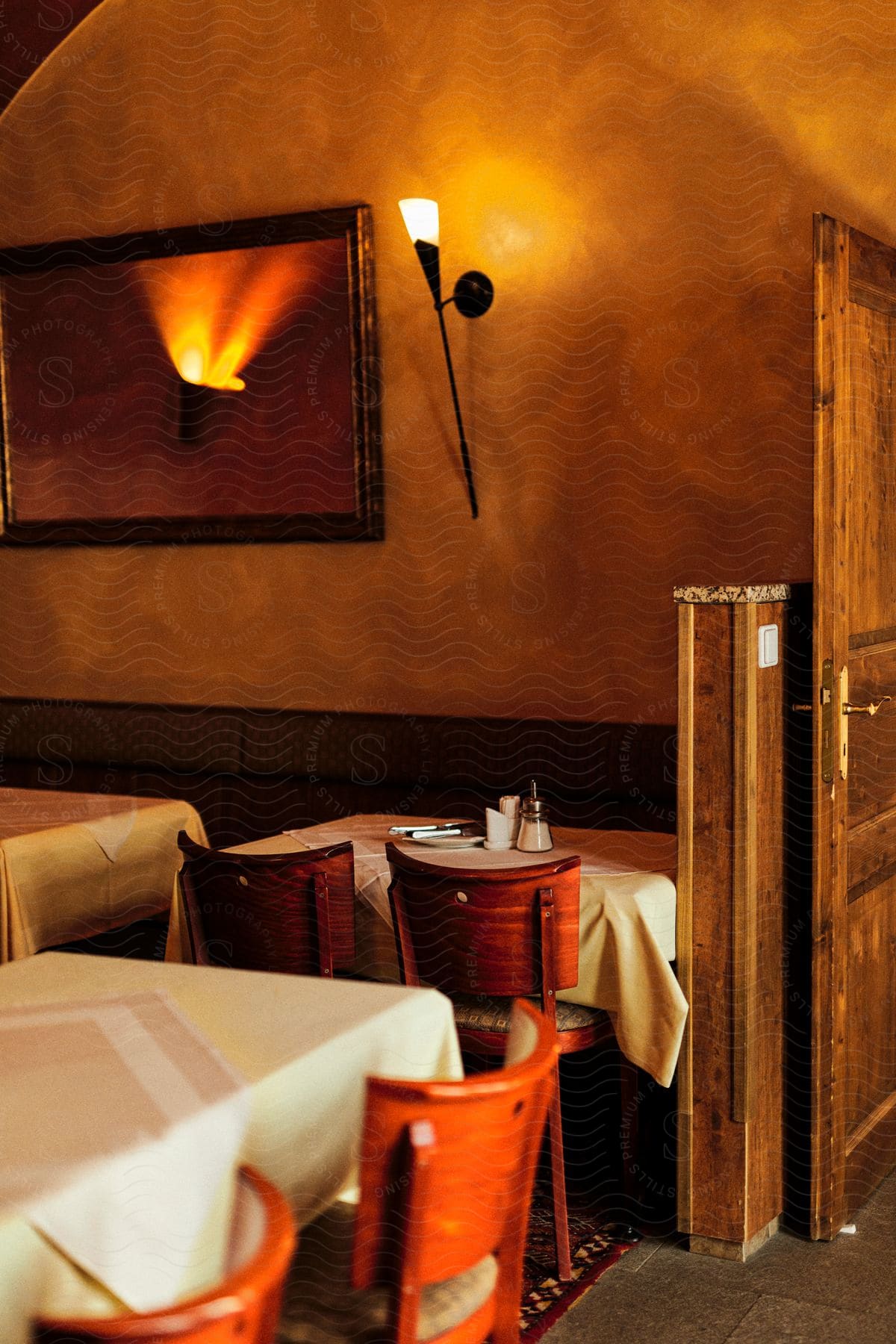 The interior of a restaurant with tables set.