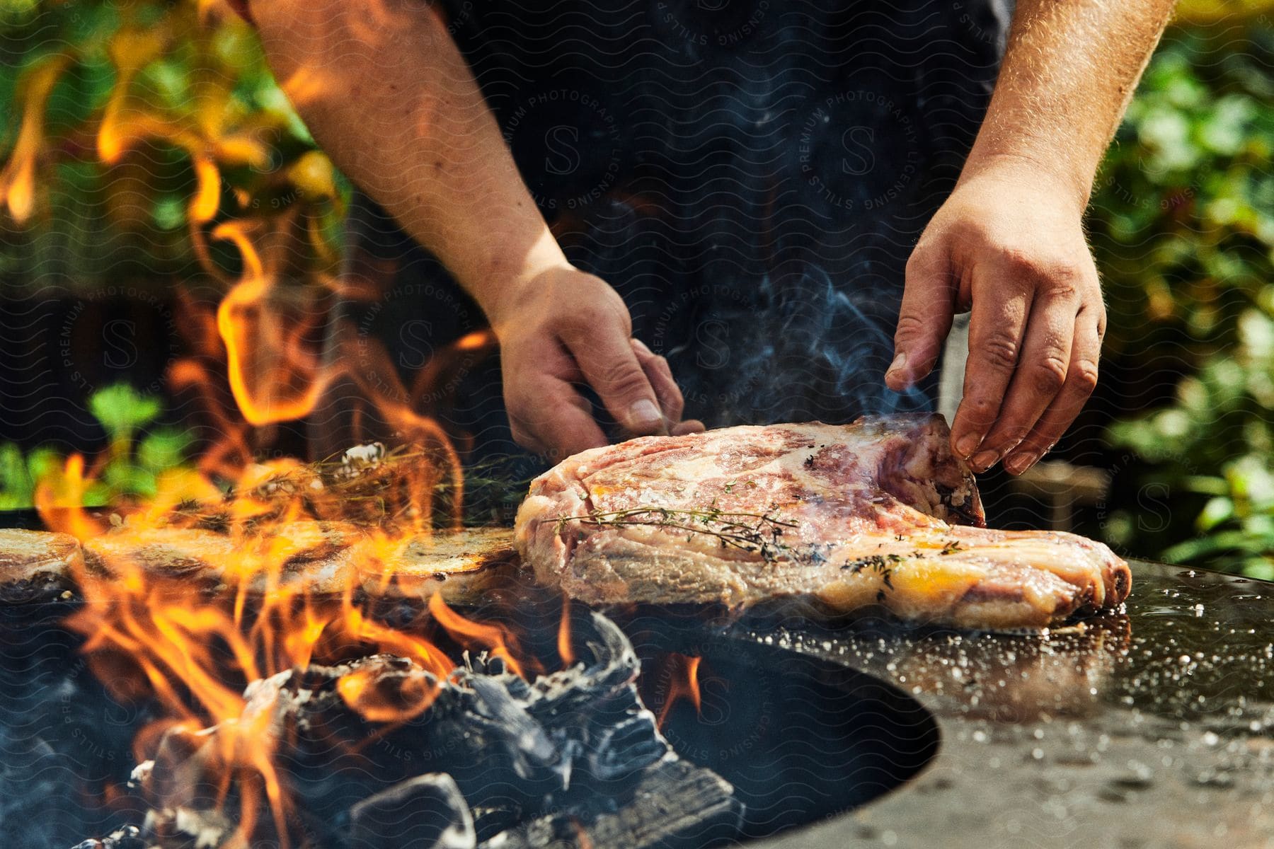 Stock photo of man puts spices on his meat in preparation for the outdoor grill