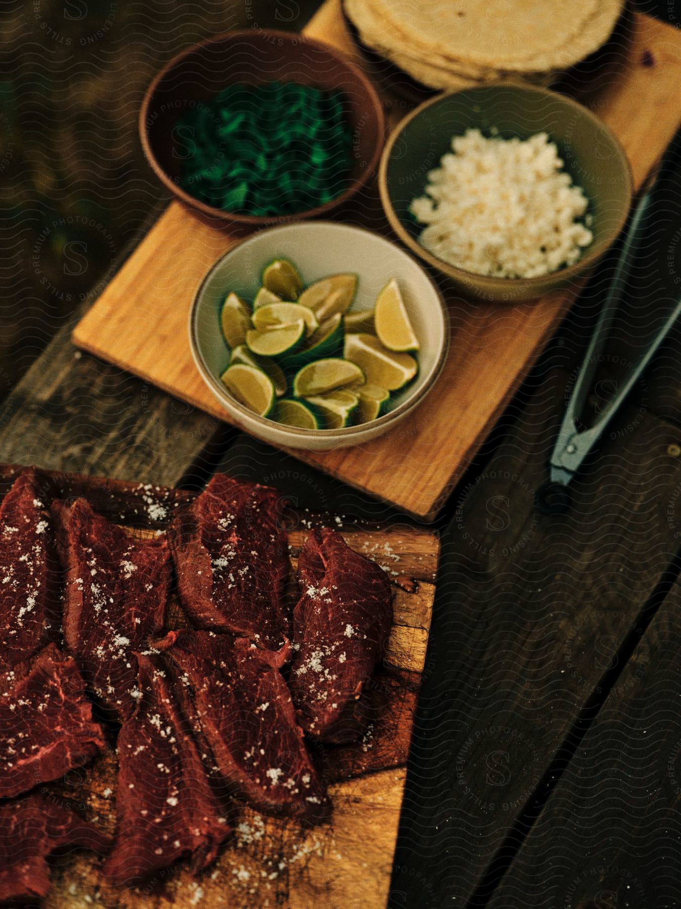 meal presentation containing meat with fruit and cheese laid over wooden boards on a wooden table