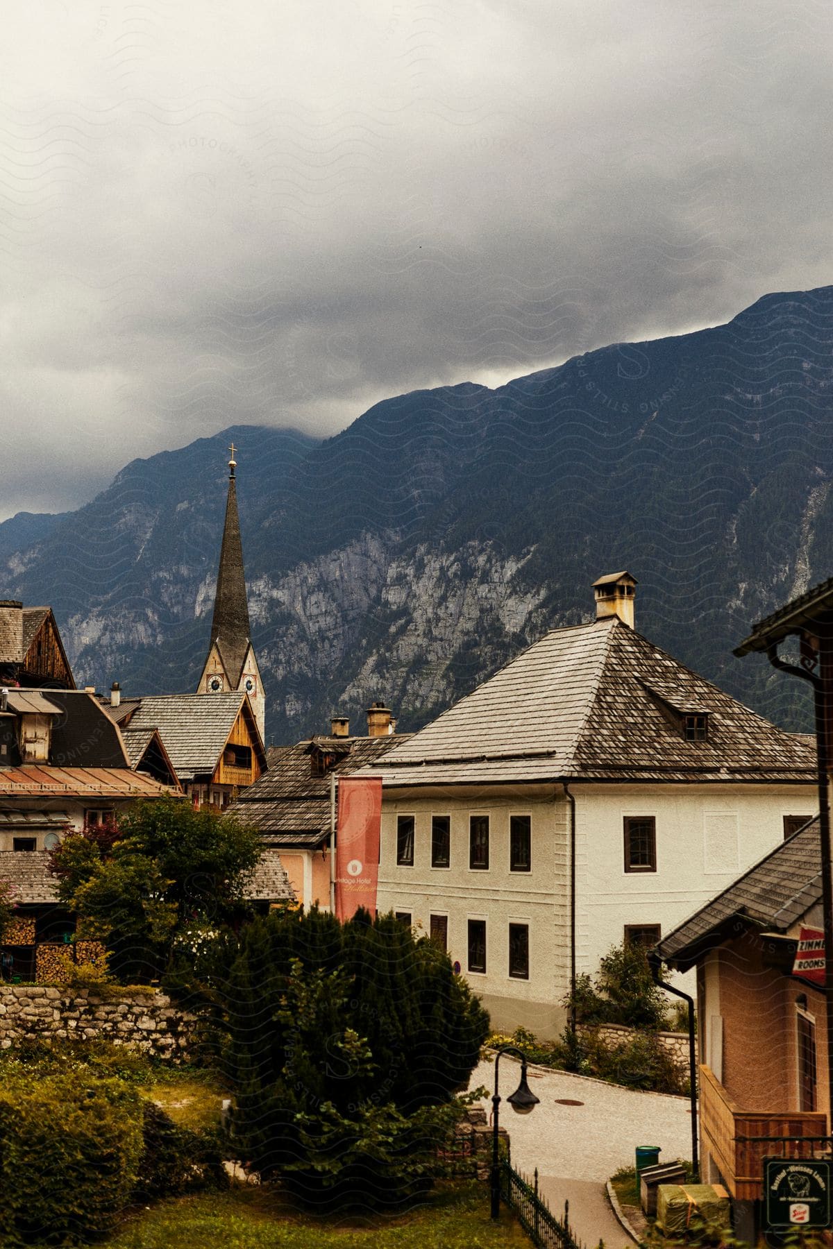 A village with a few houses and a tall church next to a huge mountain