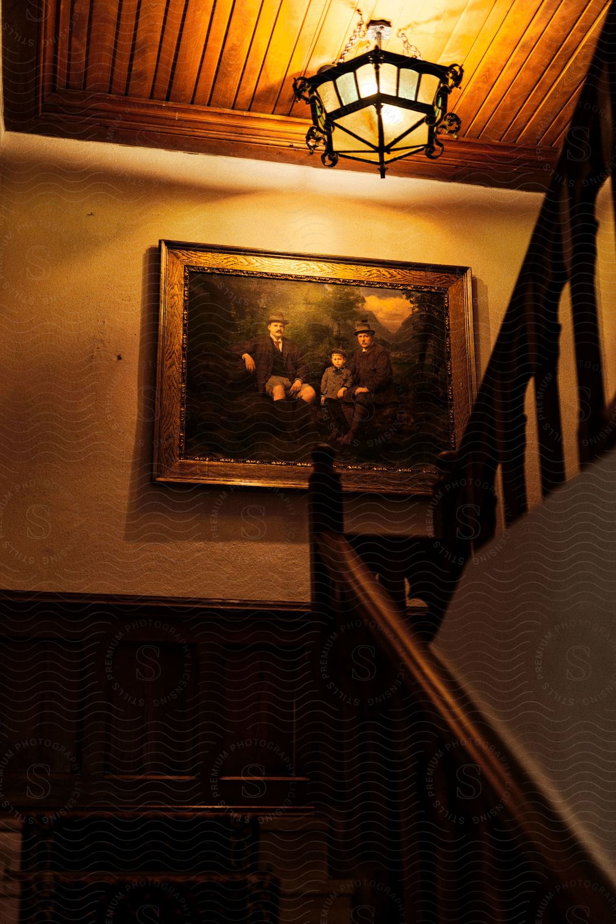 A warm, inviting staircase lit by an antique lantern, with a classic family portrait adorning the wall.