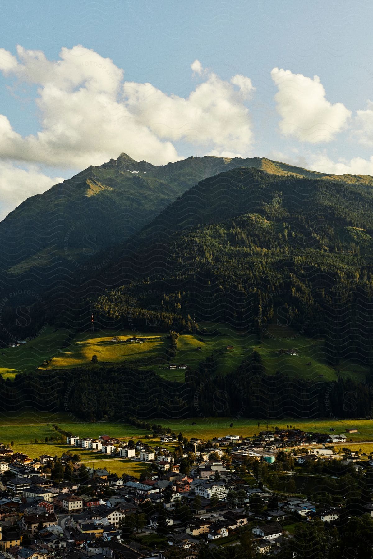 Aerial of a rural town surrounded by lush green mountains.