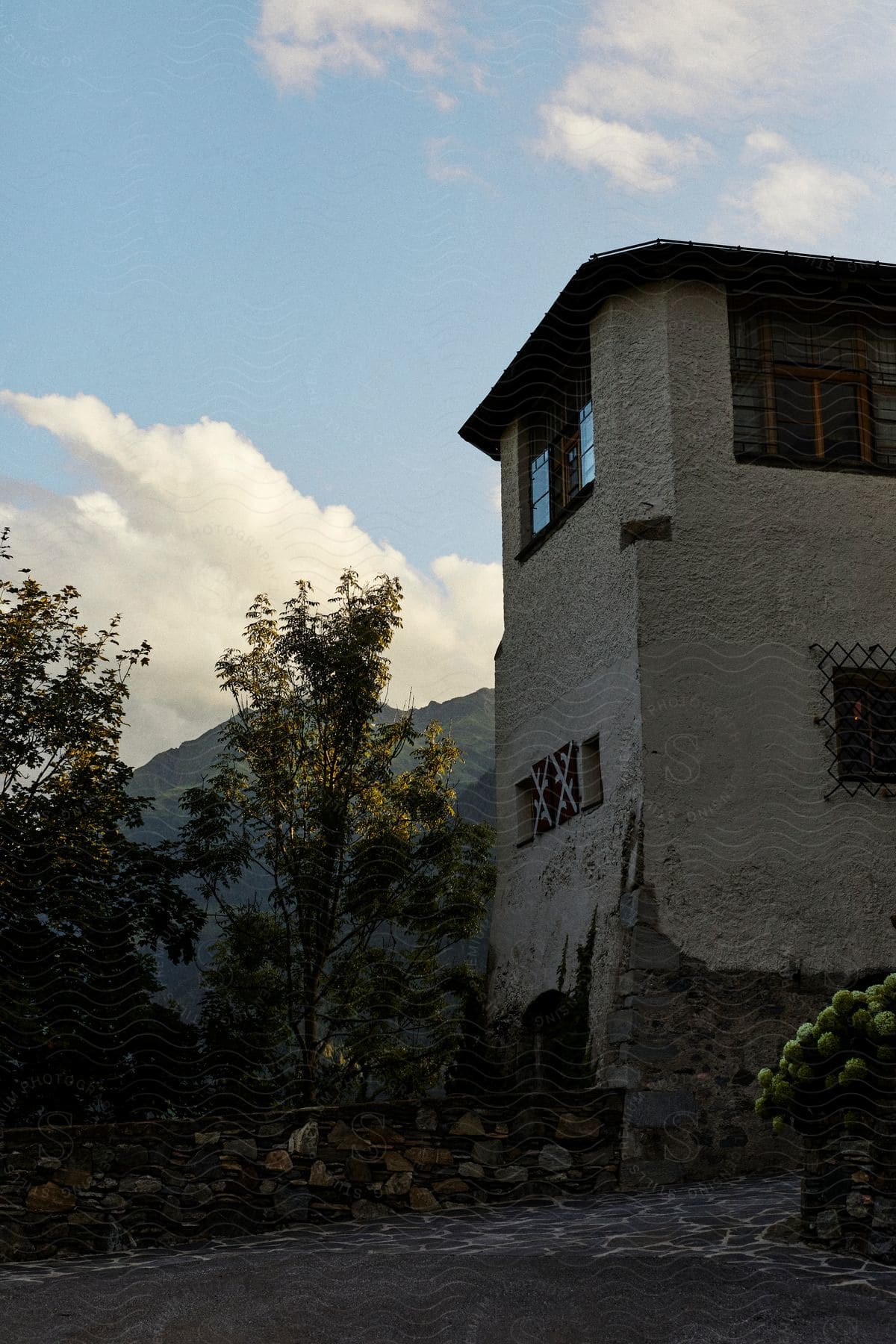 Ancient concrete building amidst a hill with a view of mountains.