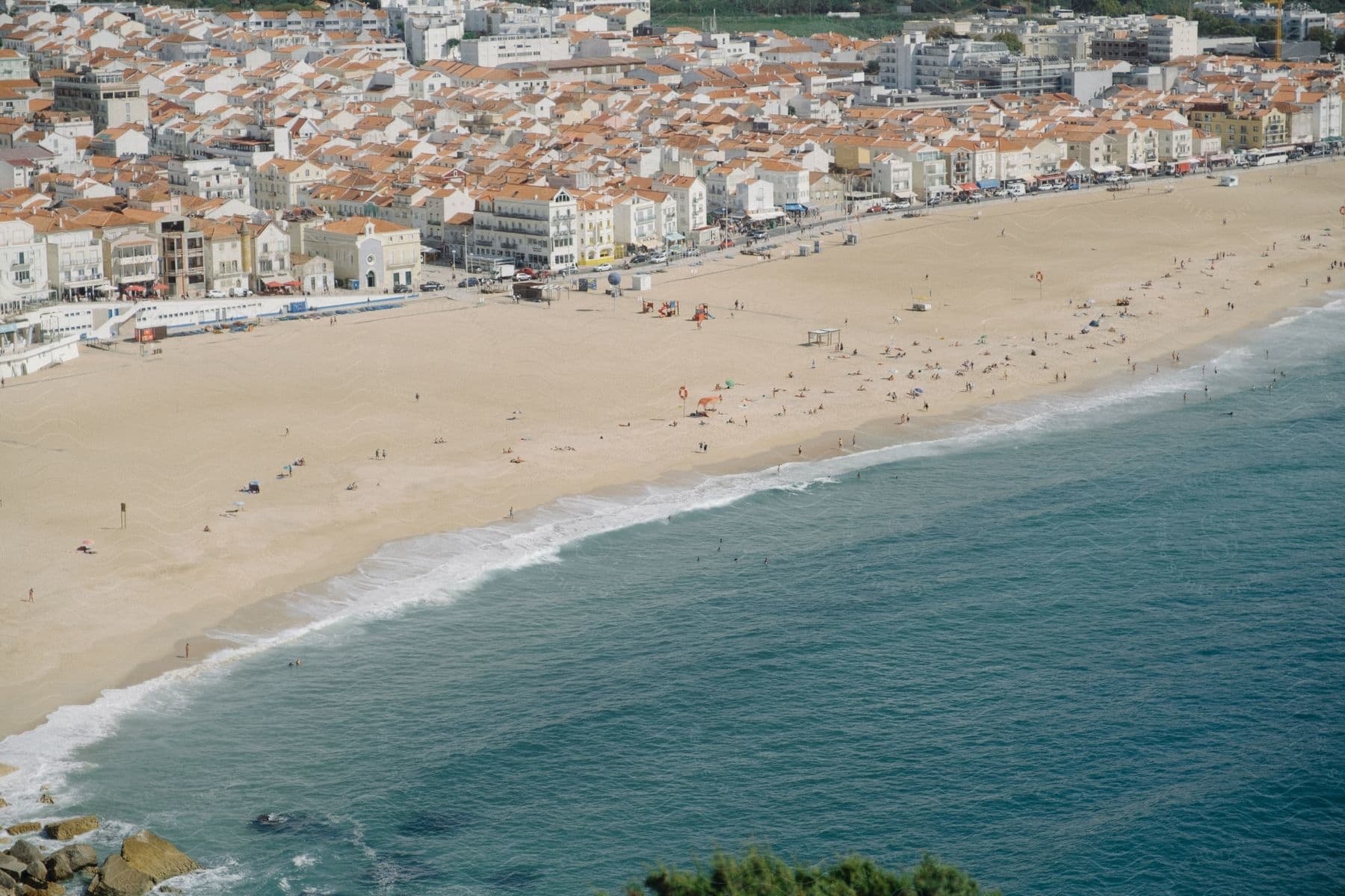 A large but sparsely populated beach near a summer town.