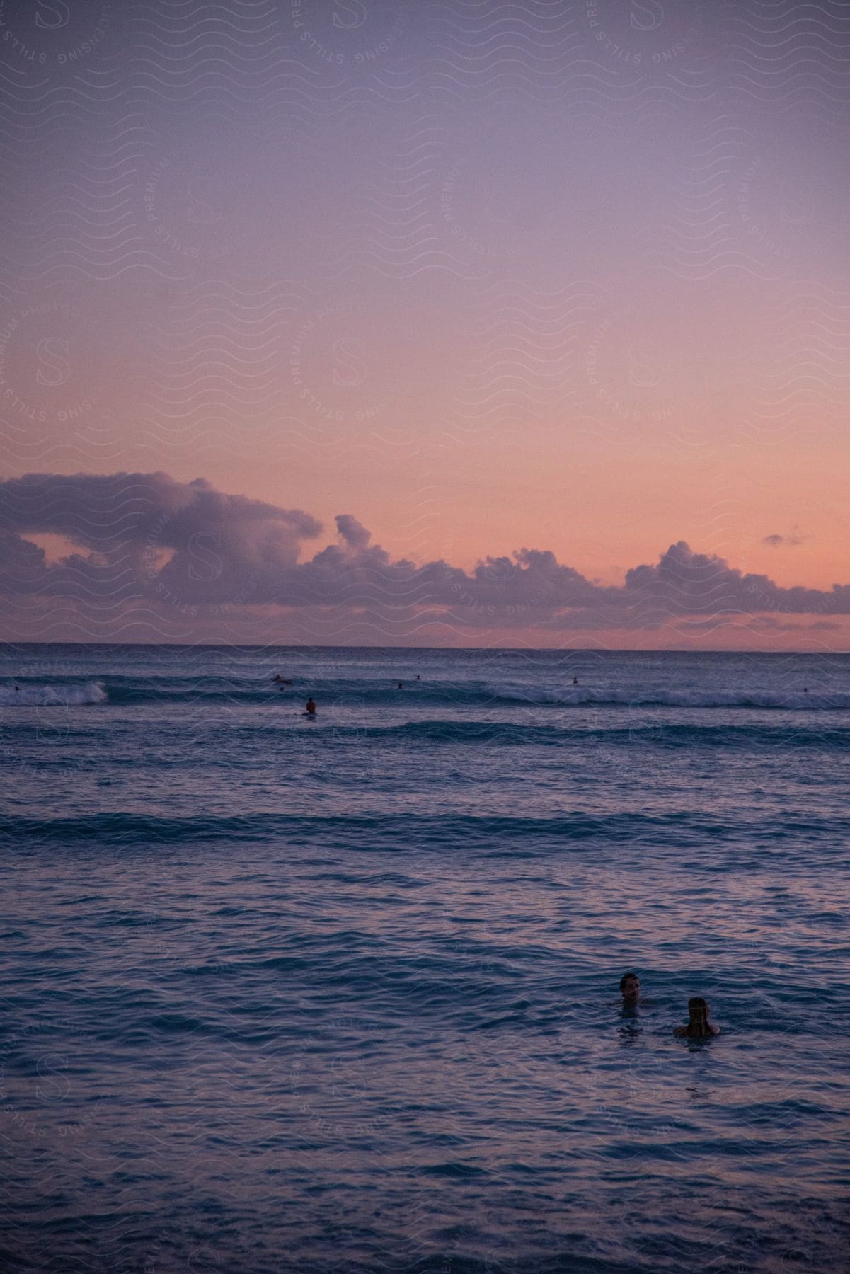 Panorama Of The Sea With People Bathing And A Purple Late Afternoon Sky