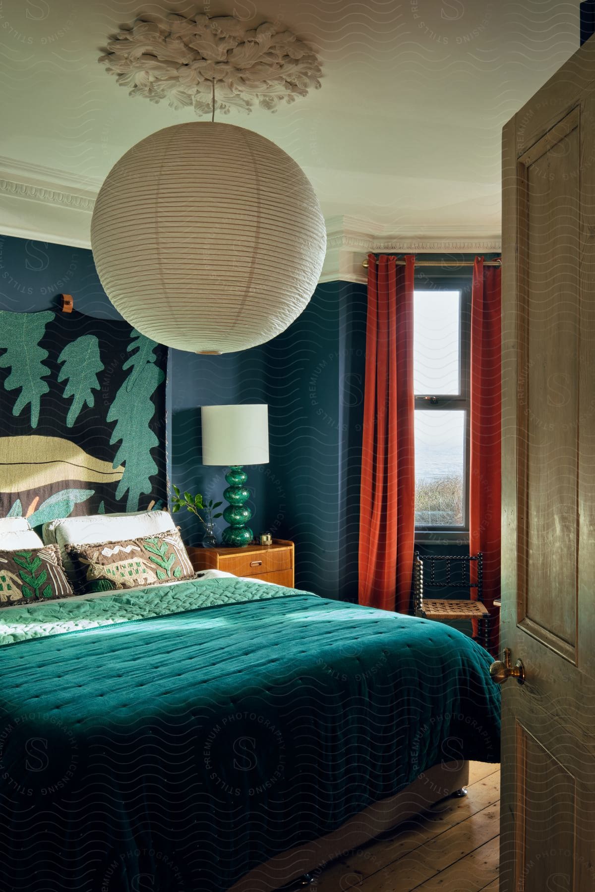 a bedroom with a round ball hanging from the ceiling during the day