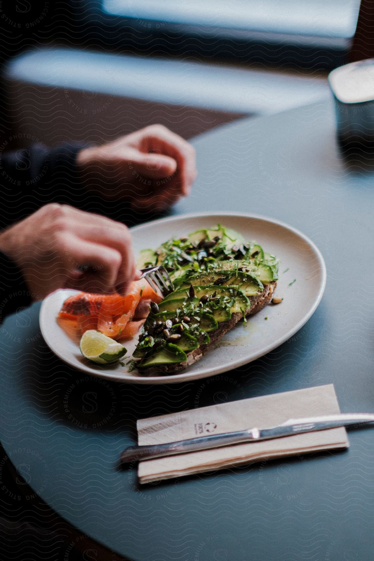 A man's hand is above his plate as he eats