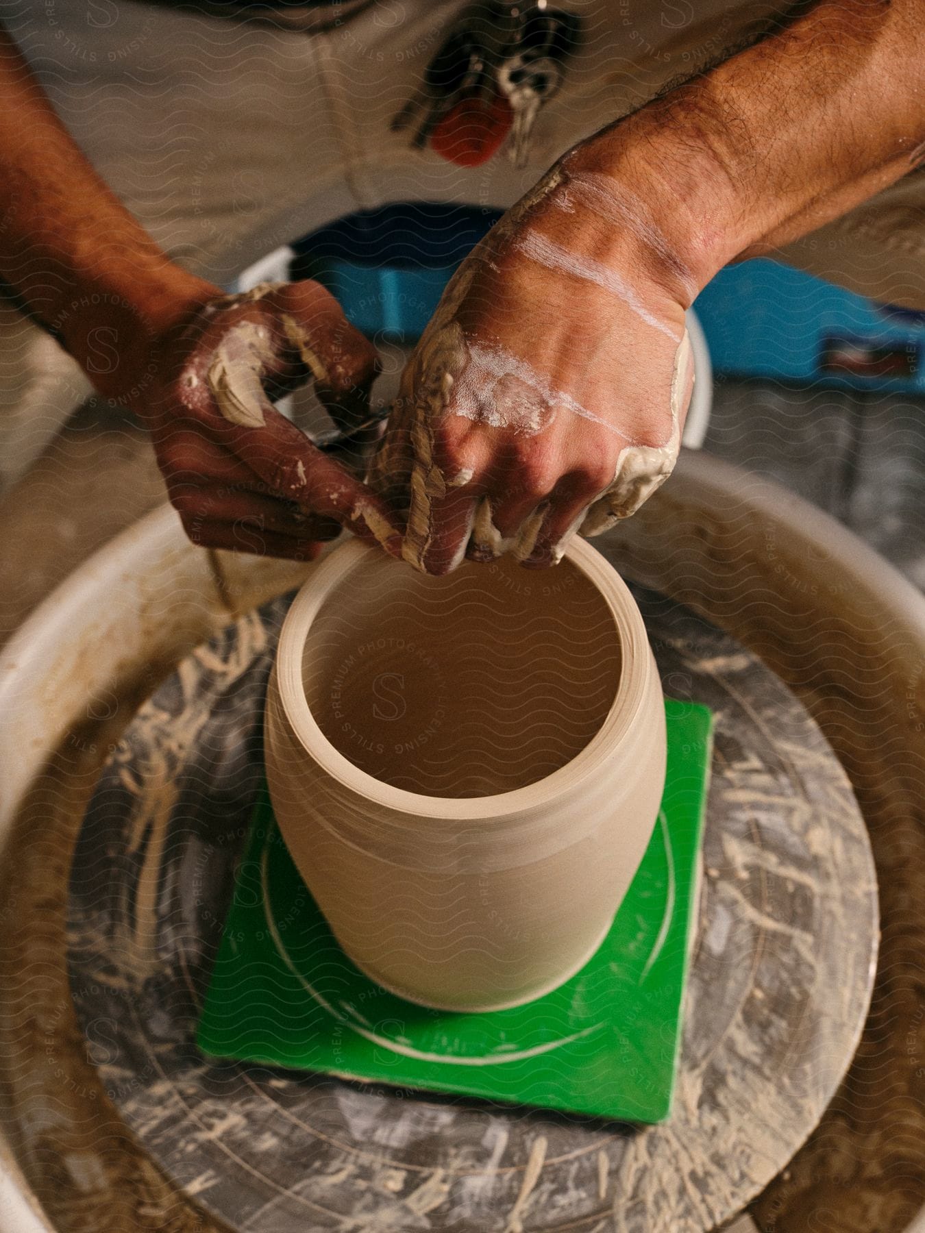 A person sculpting pottery on a pottery wheel.