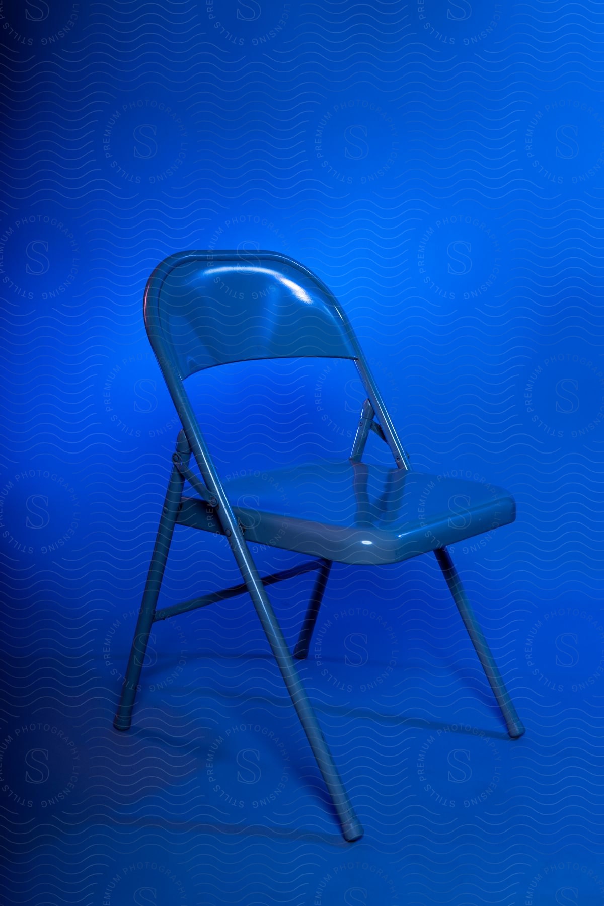 A blue chair sitting in a bright blue room.