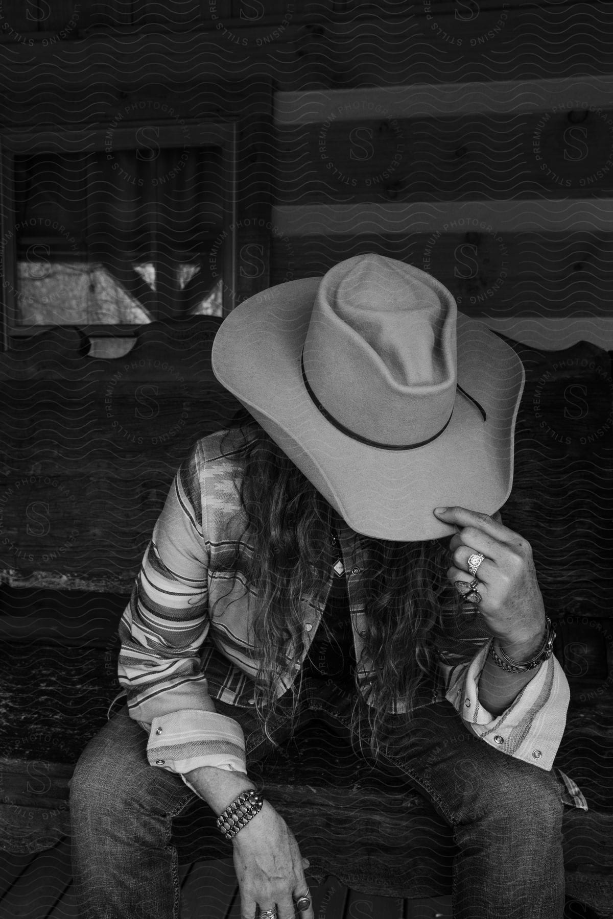 A woman modeling some cowboy clothing and a hat