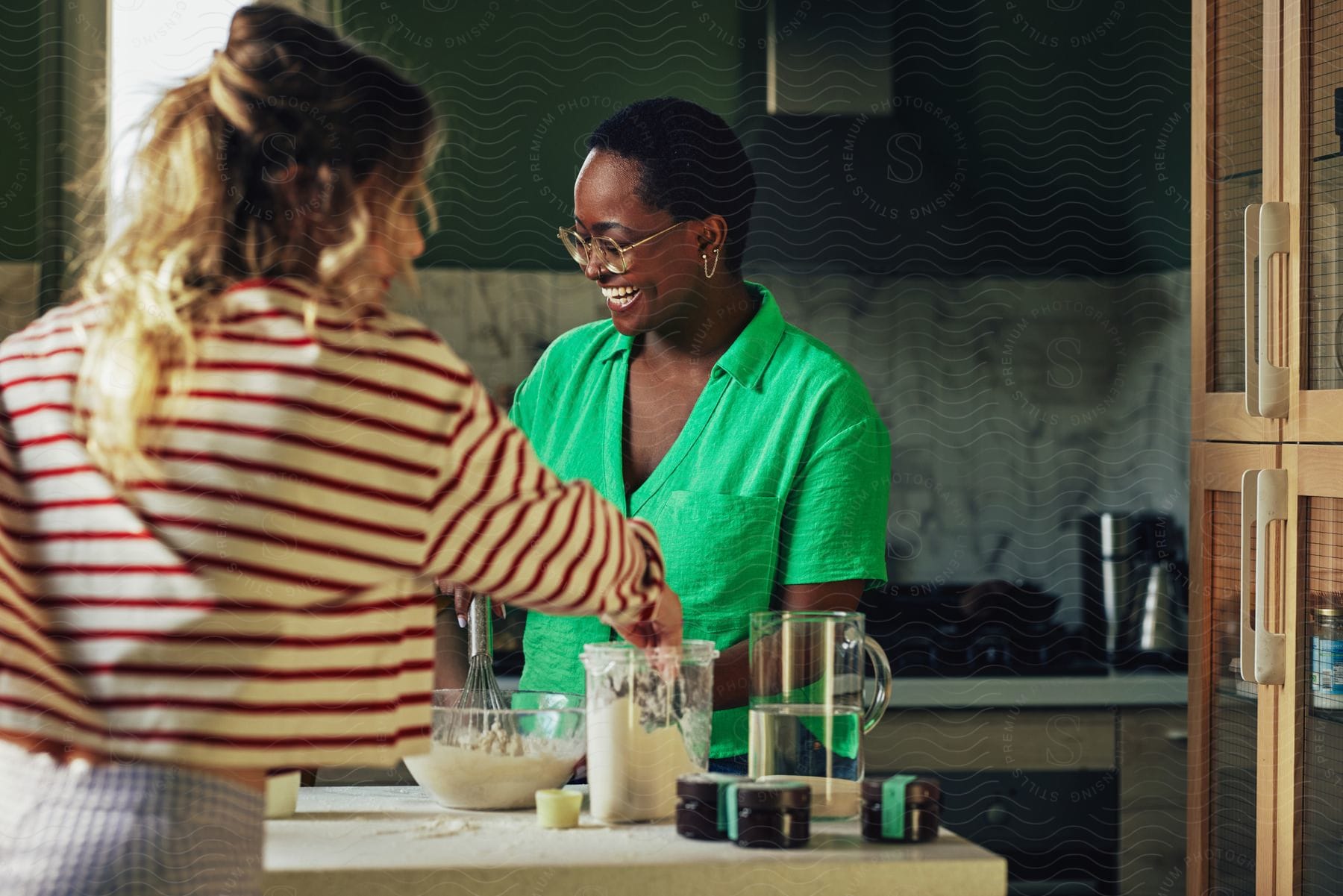 Two women cooking food in a kitchen together