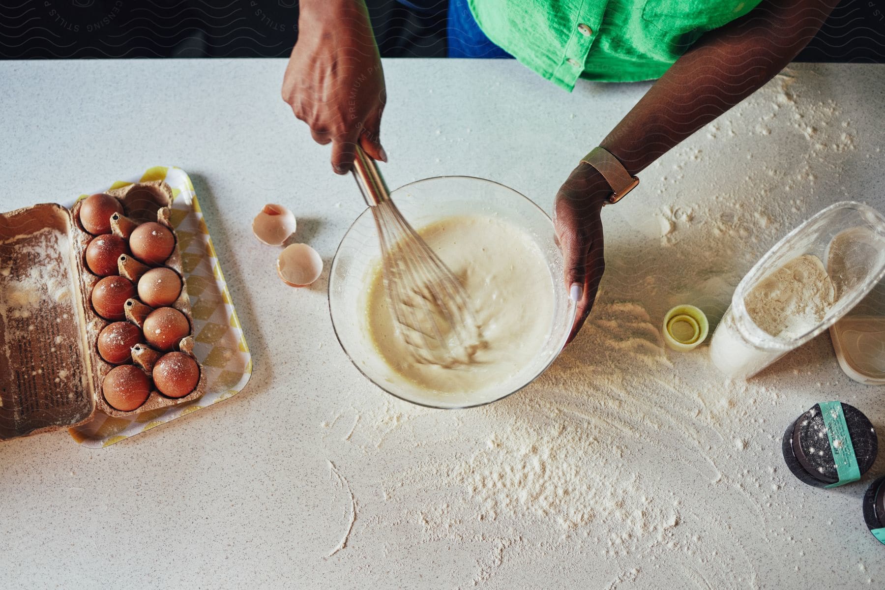 A person mixing ingredients in a transparent bowl.