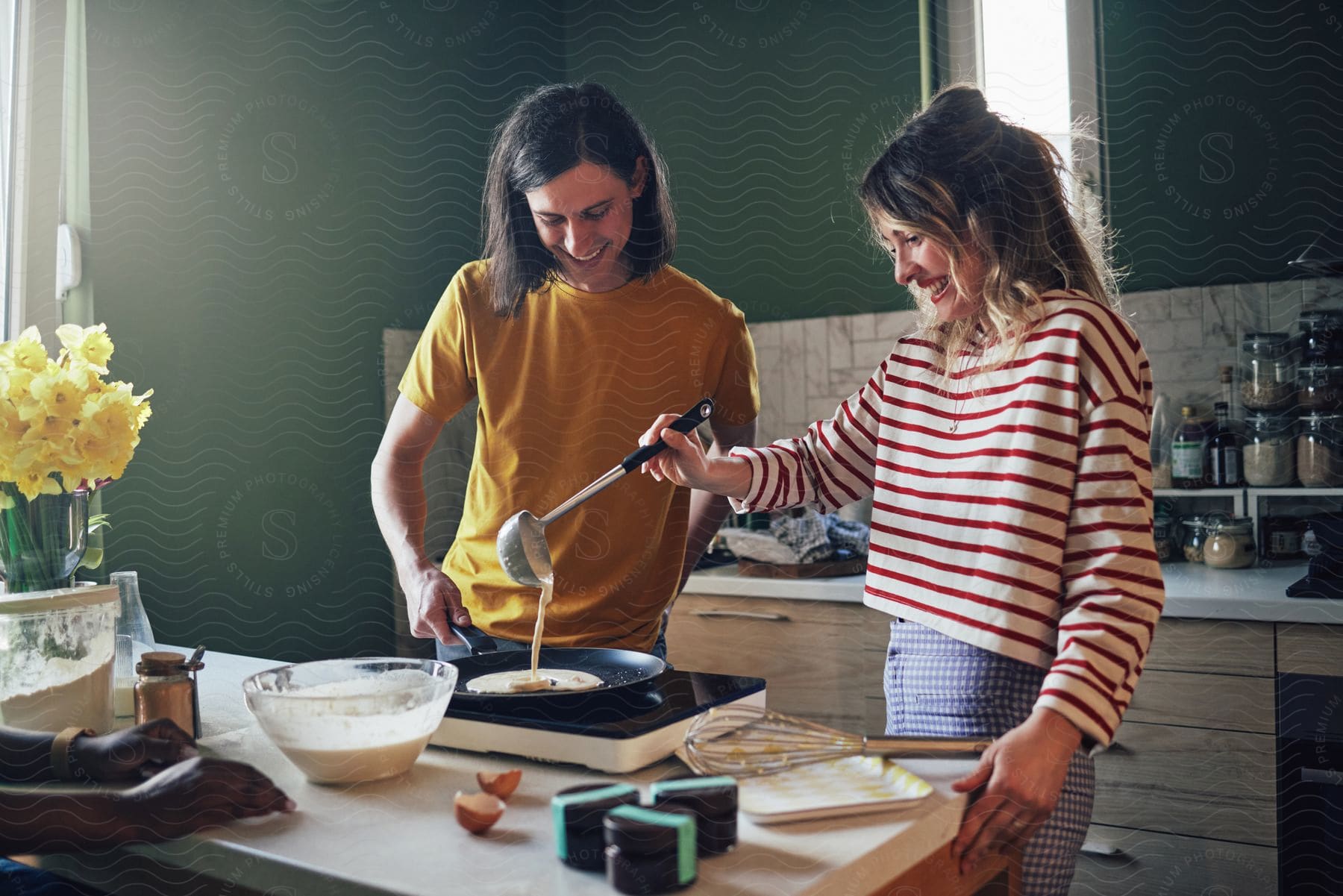 Two people making some food in a kitchen