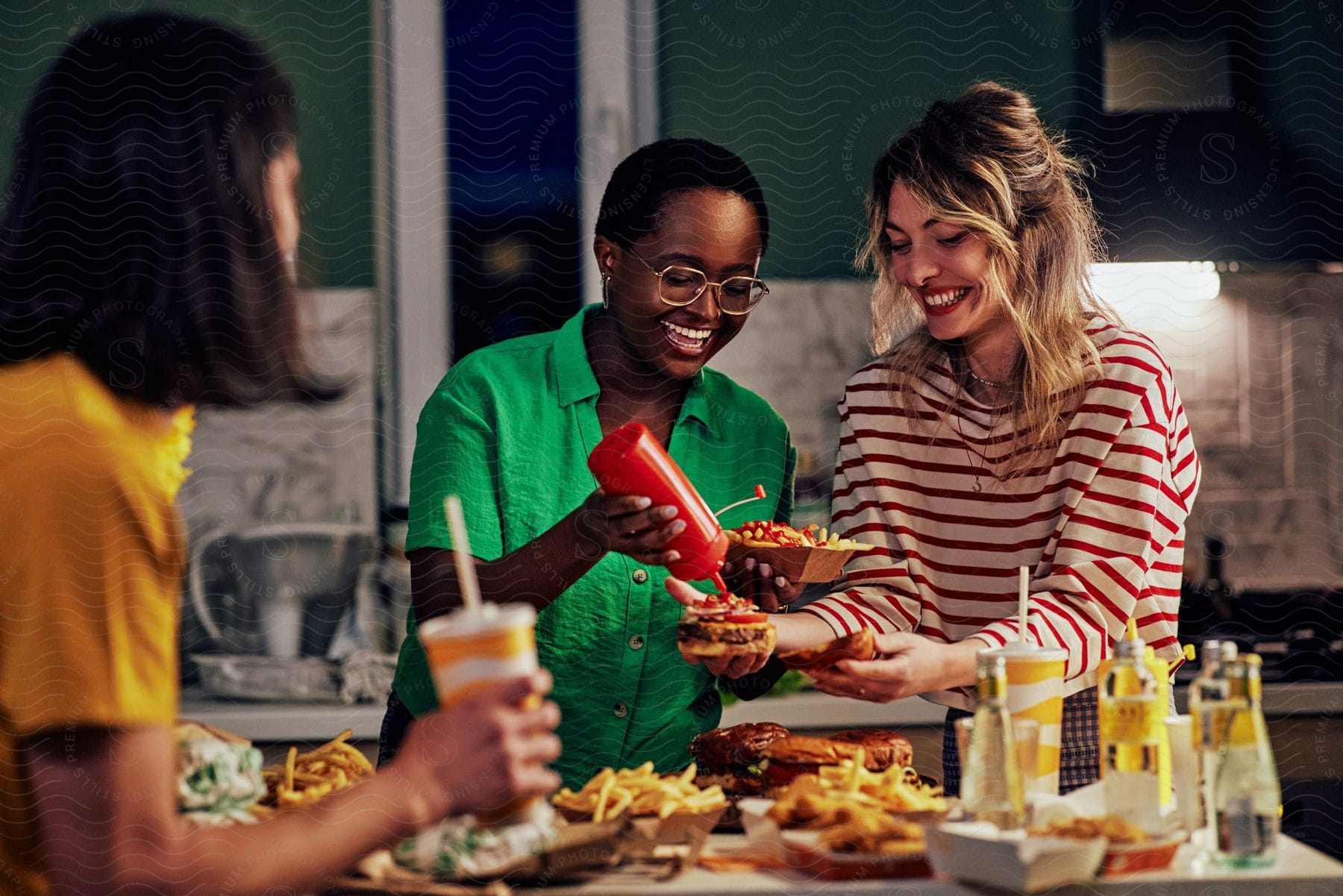 A group of friends have fun with a meal of burgers and fries