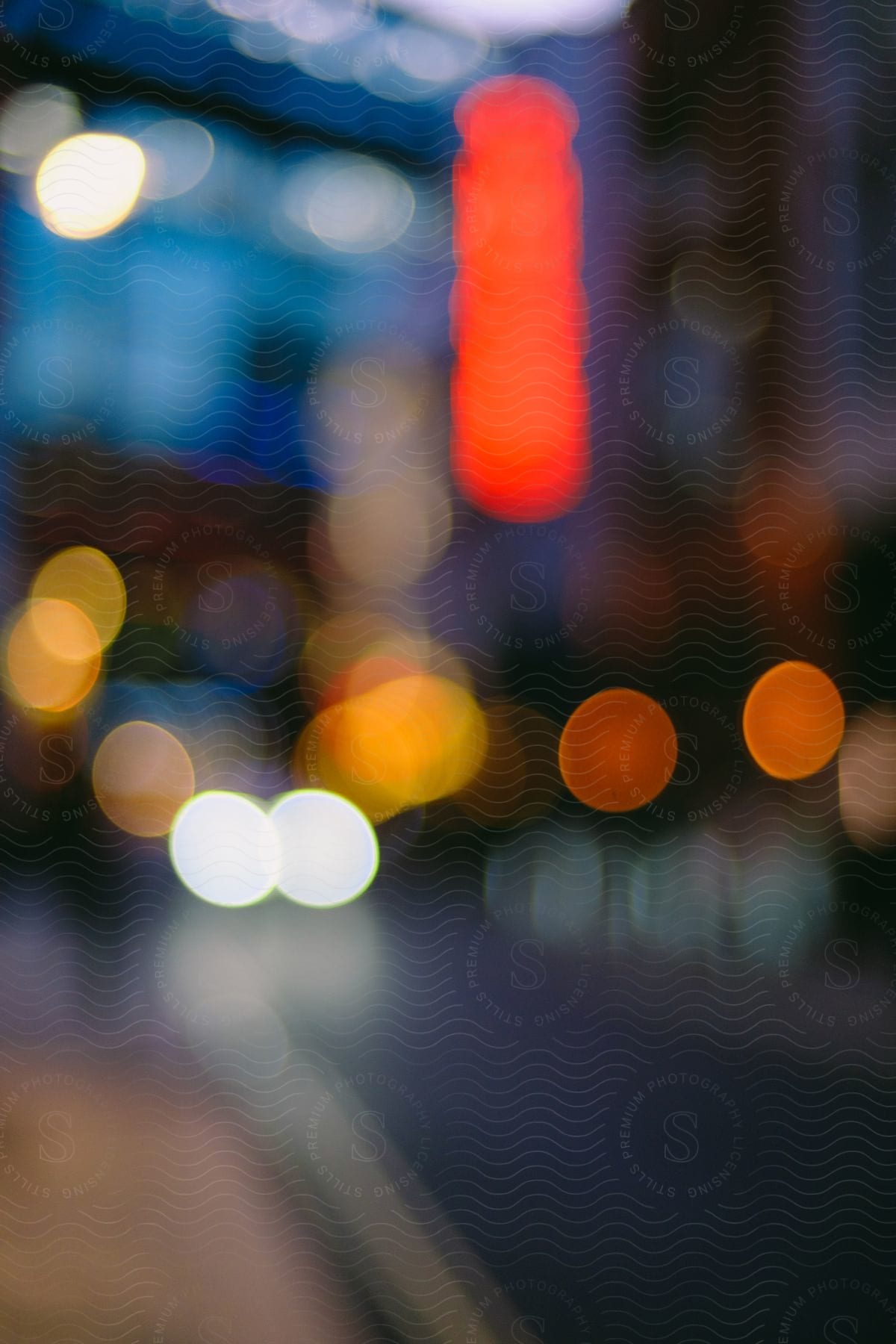 Blurred street and building lights form spots of different colors at night.