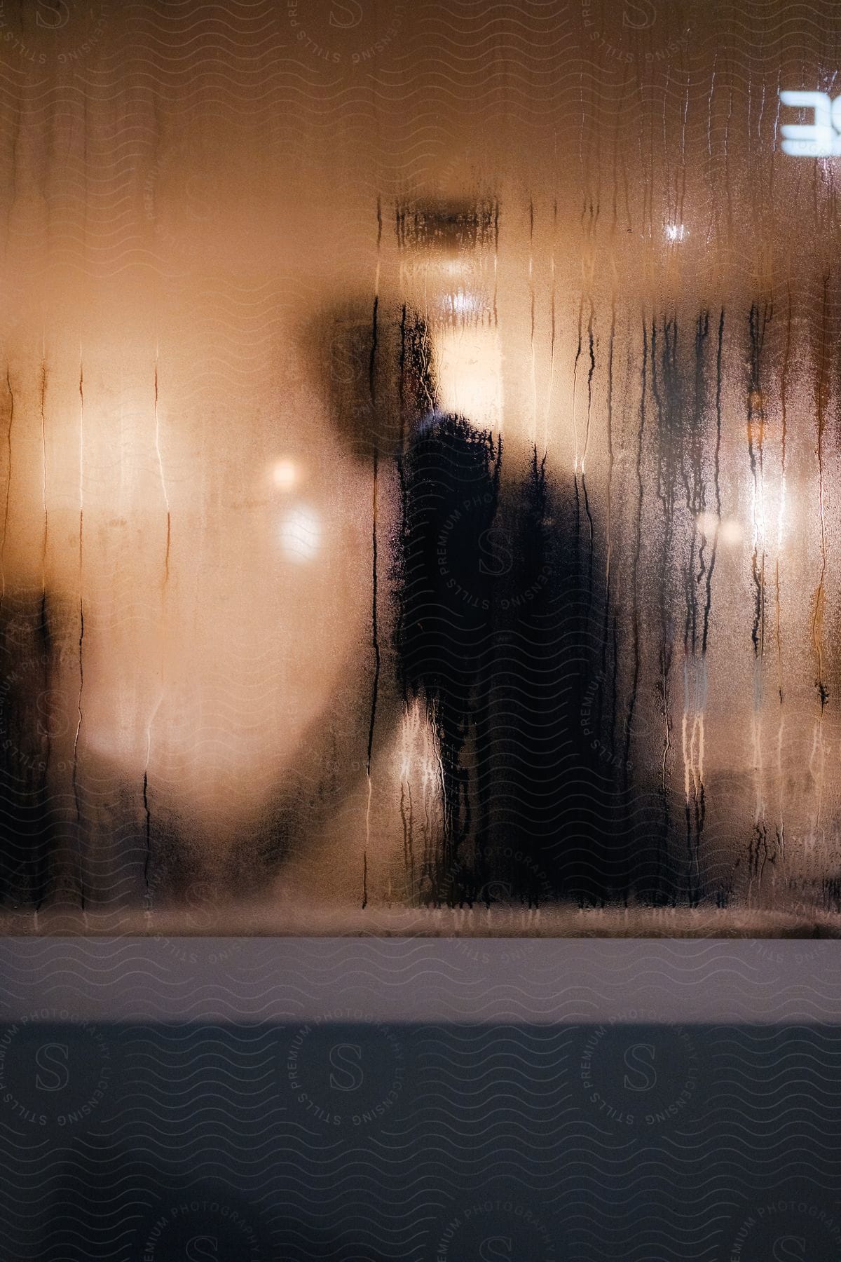 Foggy window obscures man standing near another person.