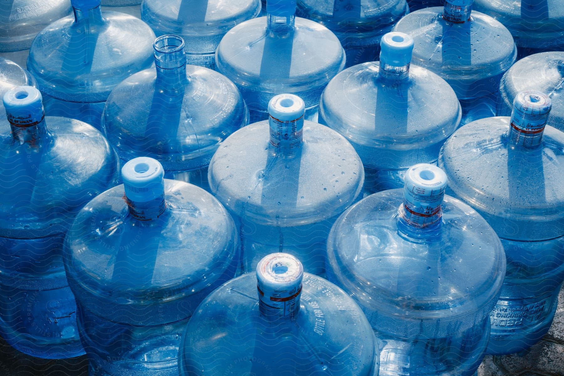 Many bottled water jugs together on the floor