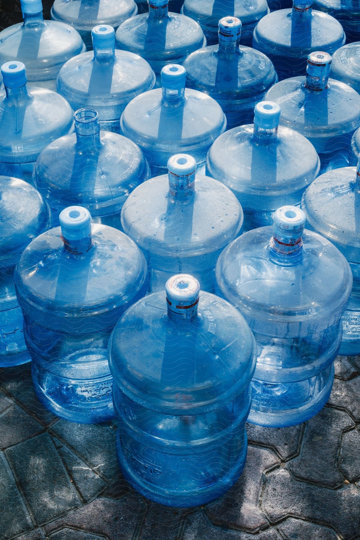 A lot of large water jugs sitting at a shop outdoors.