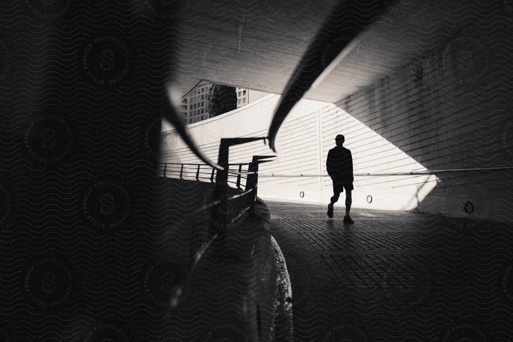 Architecture of a black and white walkway and the silhouette of a man walking