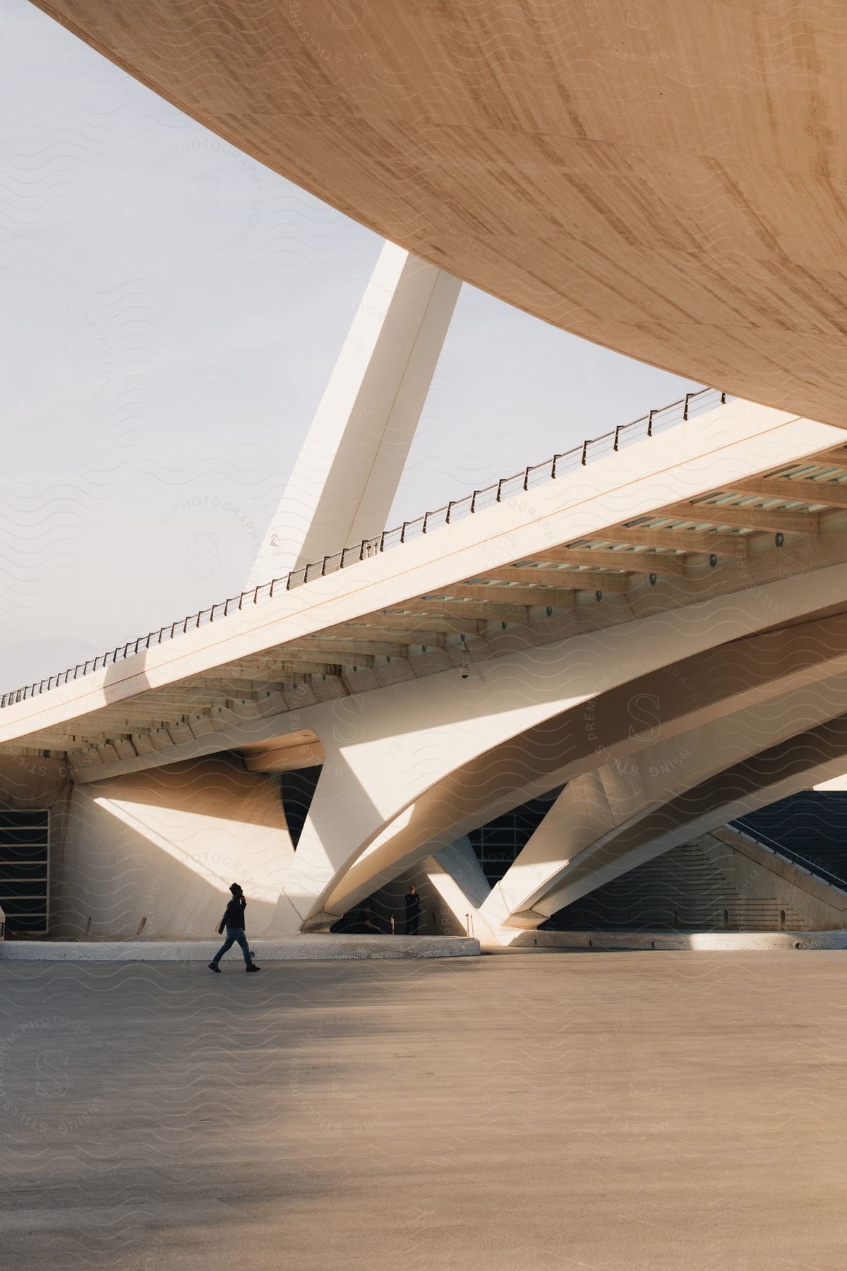 person walking under a bridge at daytime