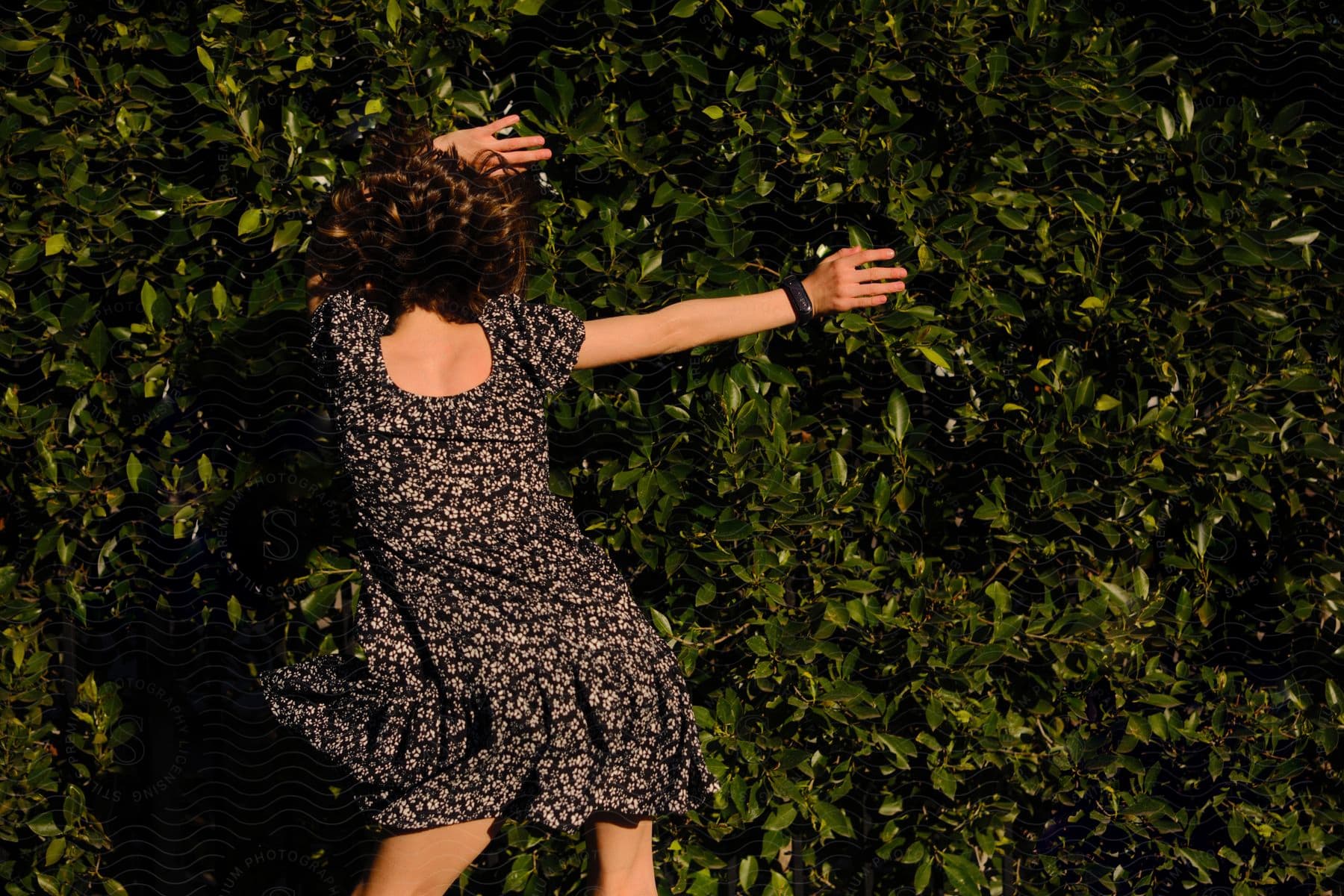 A woman rolling in grass modeling a dress