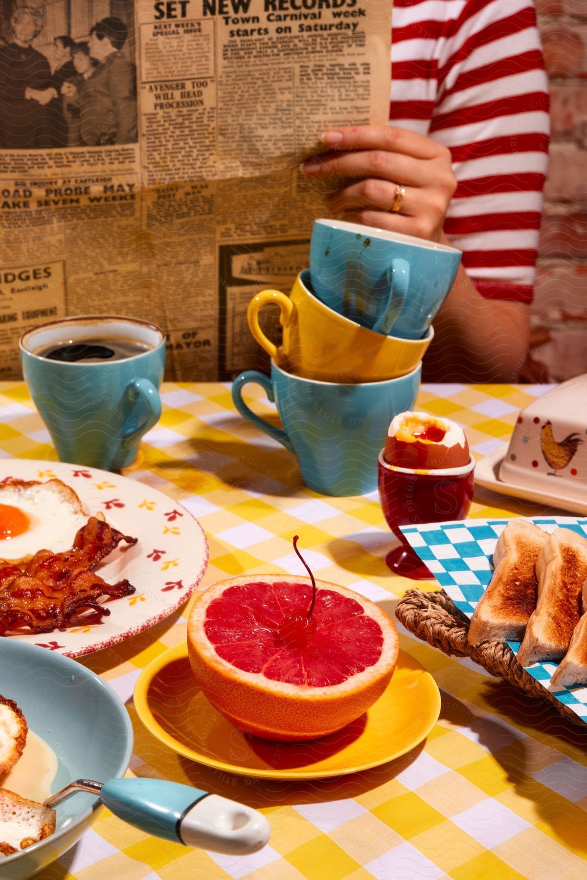 Table with cups of coffee fried eggs and an orange cut in half