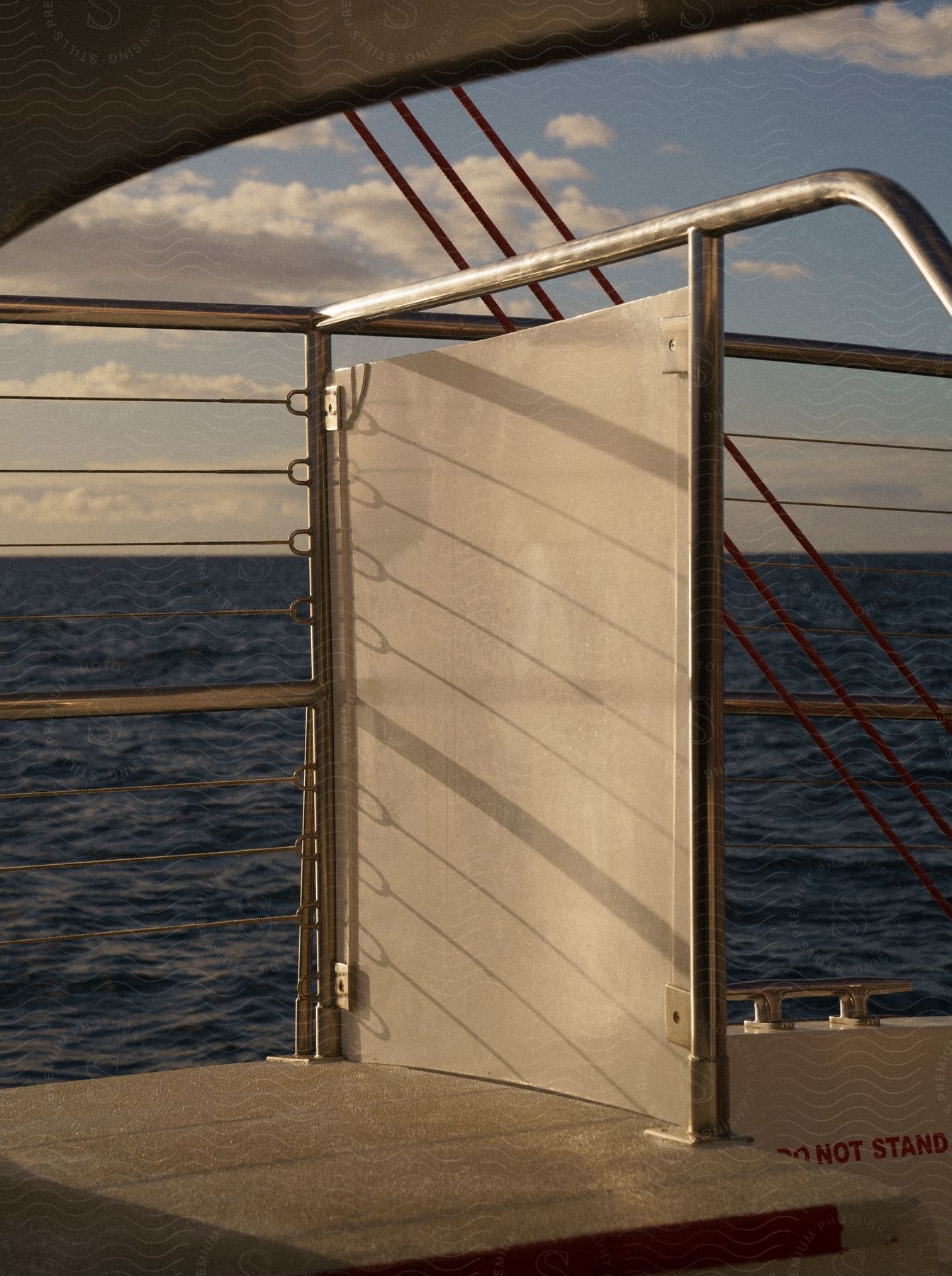 Ocean stretches beyond ship's rails, framed by a safety barrier.