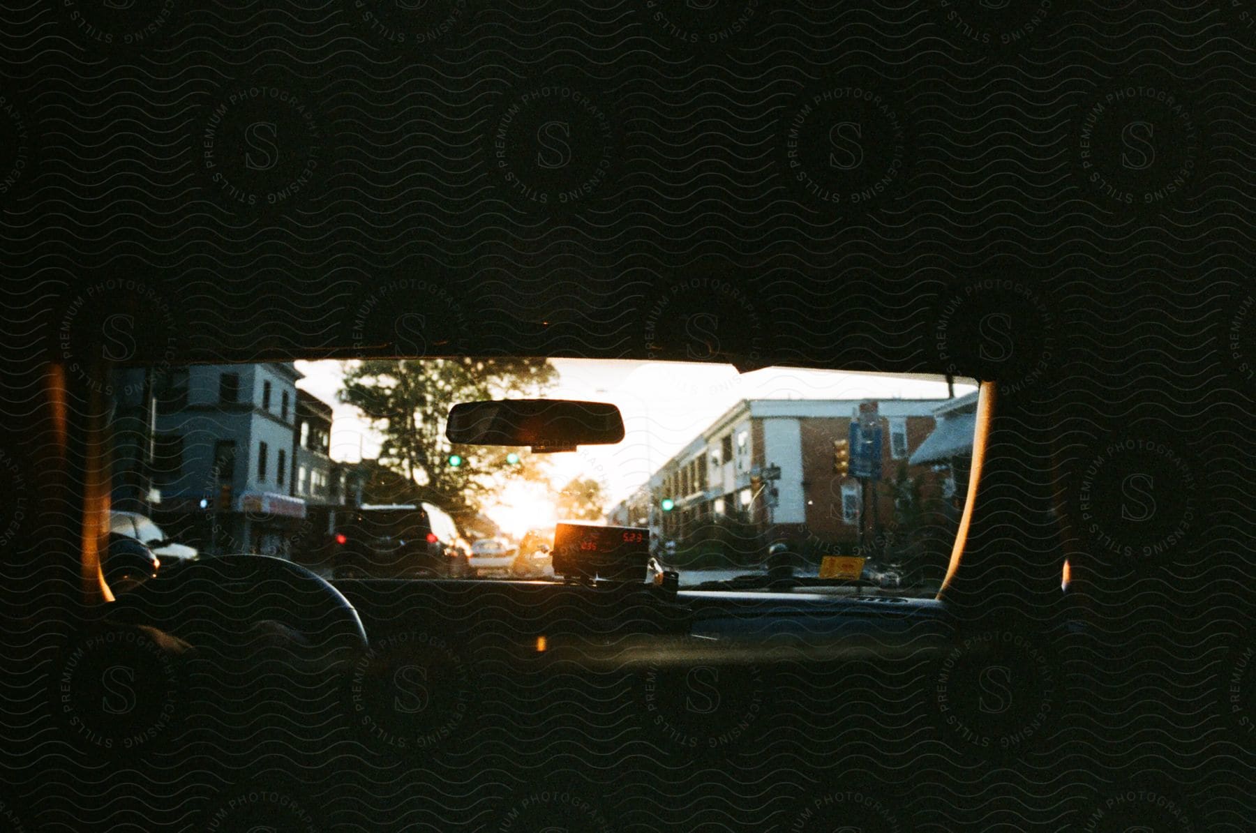 interior of a moving car with someone at the driving seat, at sunset