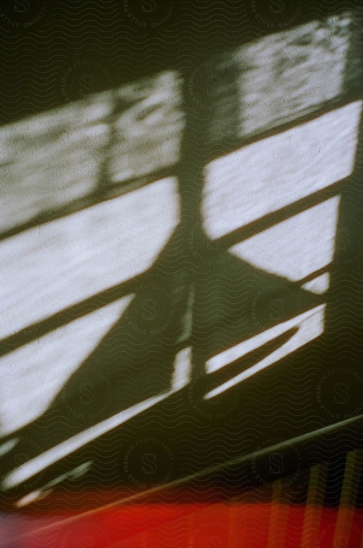 A shadow of a toy sailboat and a window frame as sunlight passes through the window.