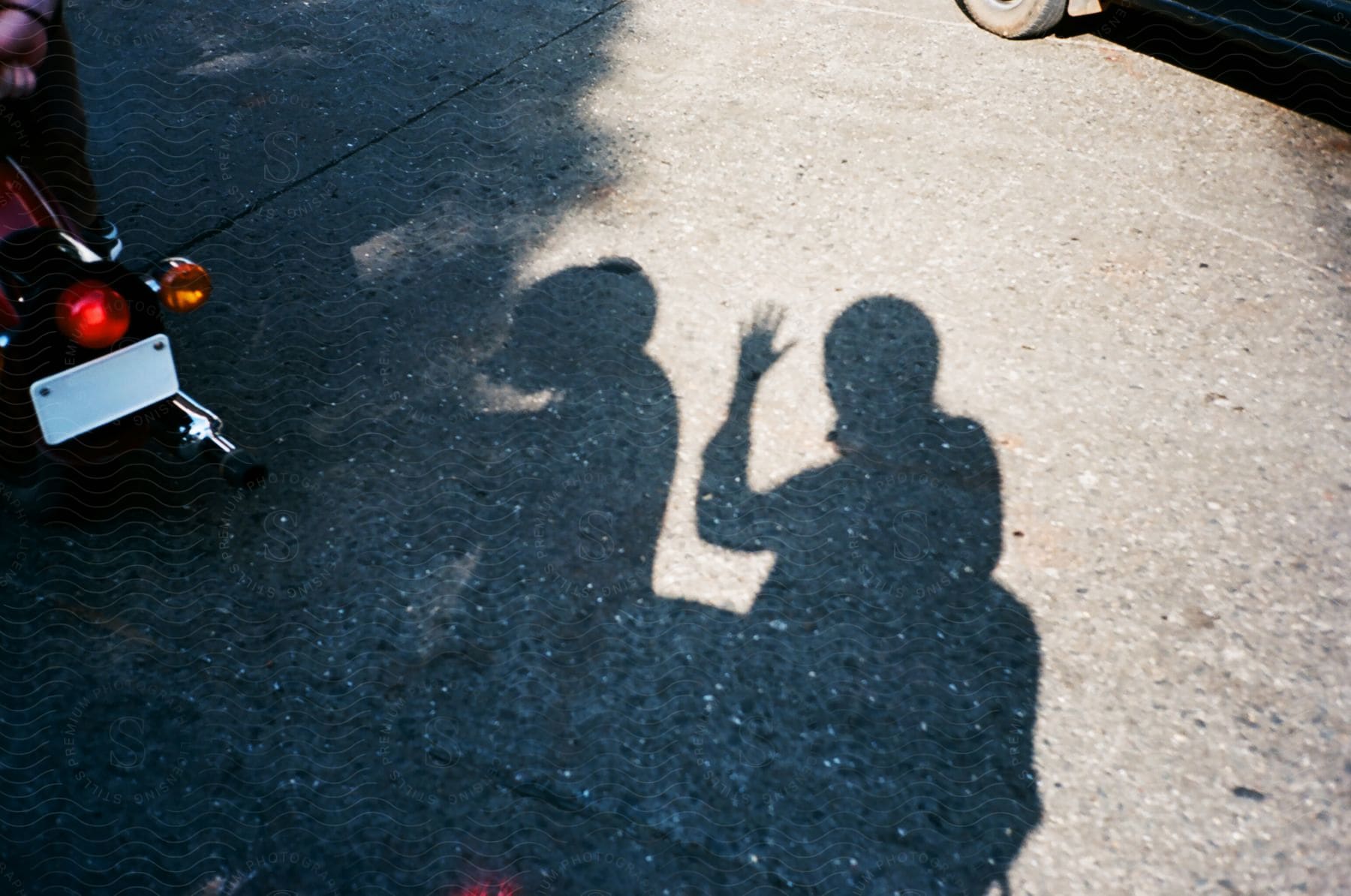 A waving shadow and the shadow of another person with a motorcycle