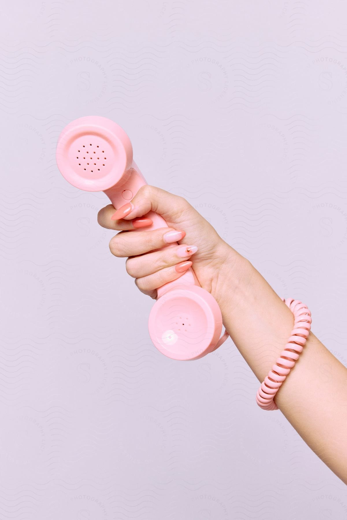 A person with decorated nails holding a pink phone.