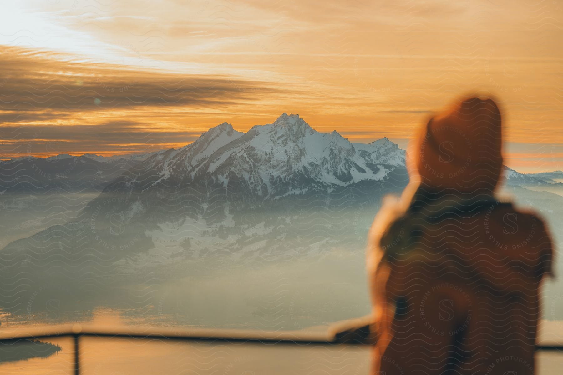 A back shot of a lady looking at the ice mountain range